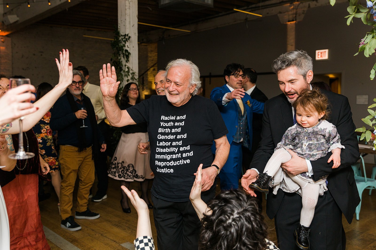  Documentary candid photo of guests dancing at nontraditional Jewish and Venezuelan wedding reception at The Joinery Chicago an Industrial loft wedding venue In Logan Square.  