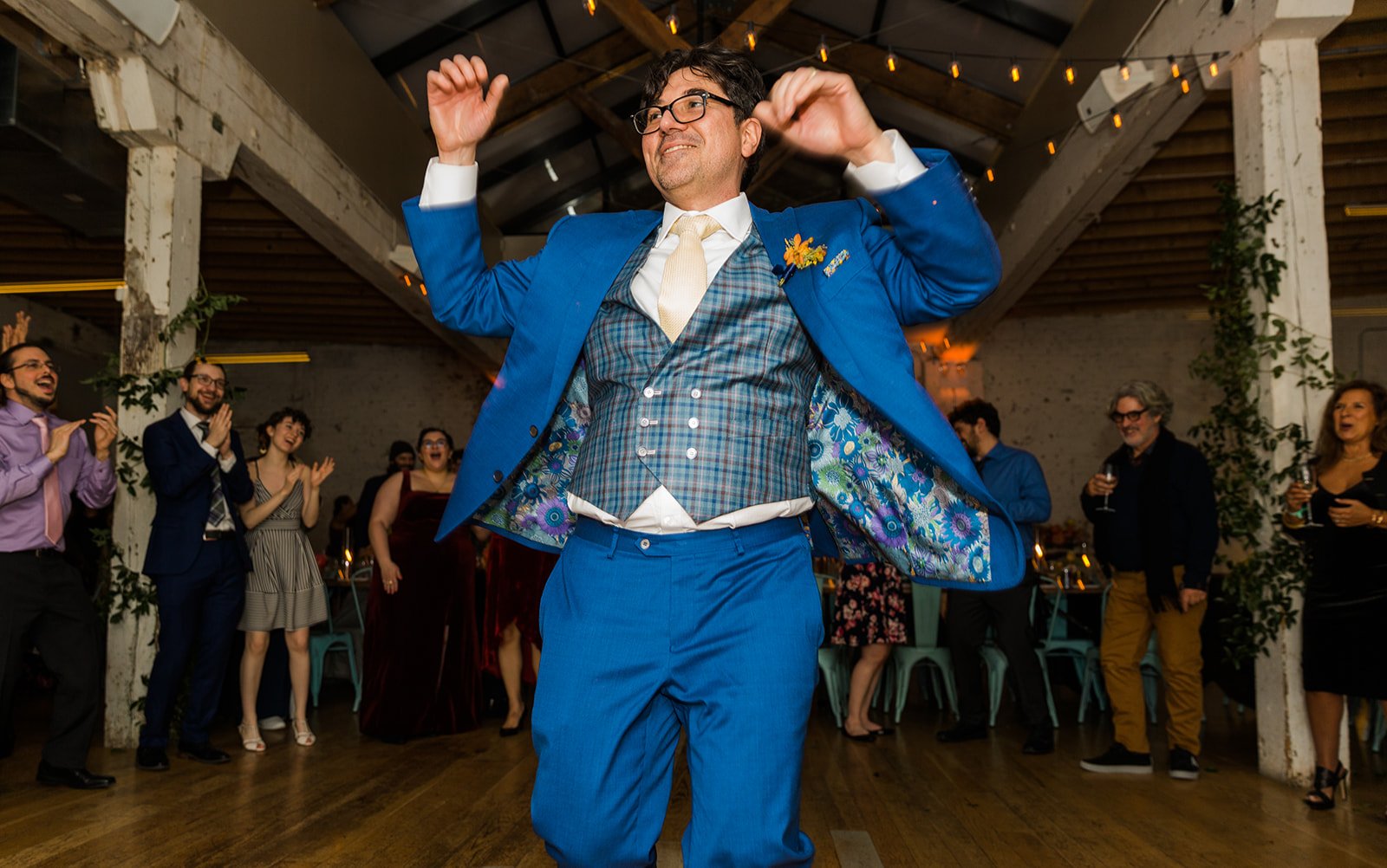  Documentary candid photo of groom dancing at nontraditional Jewish and Venezuelan wedding reception at The Joinery Chicago an Industrial loft wedding venue In Logan Square.  