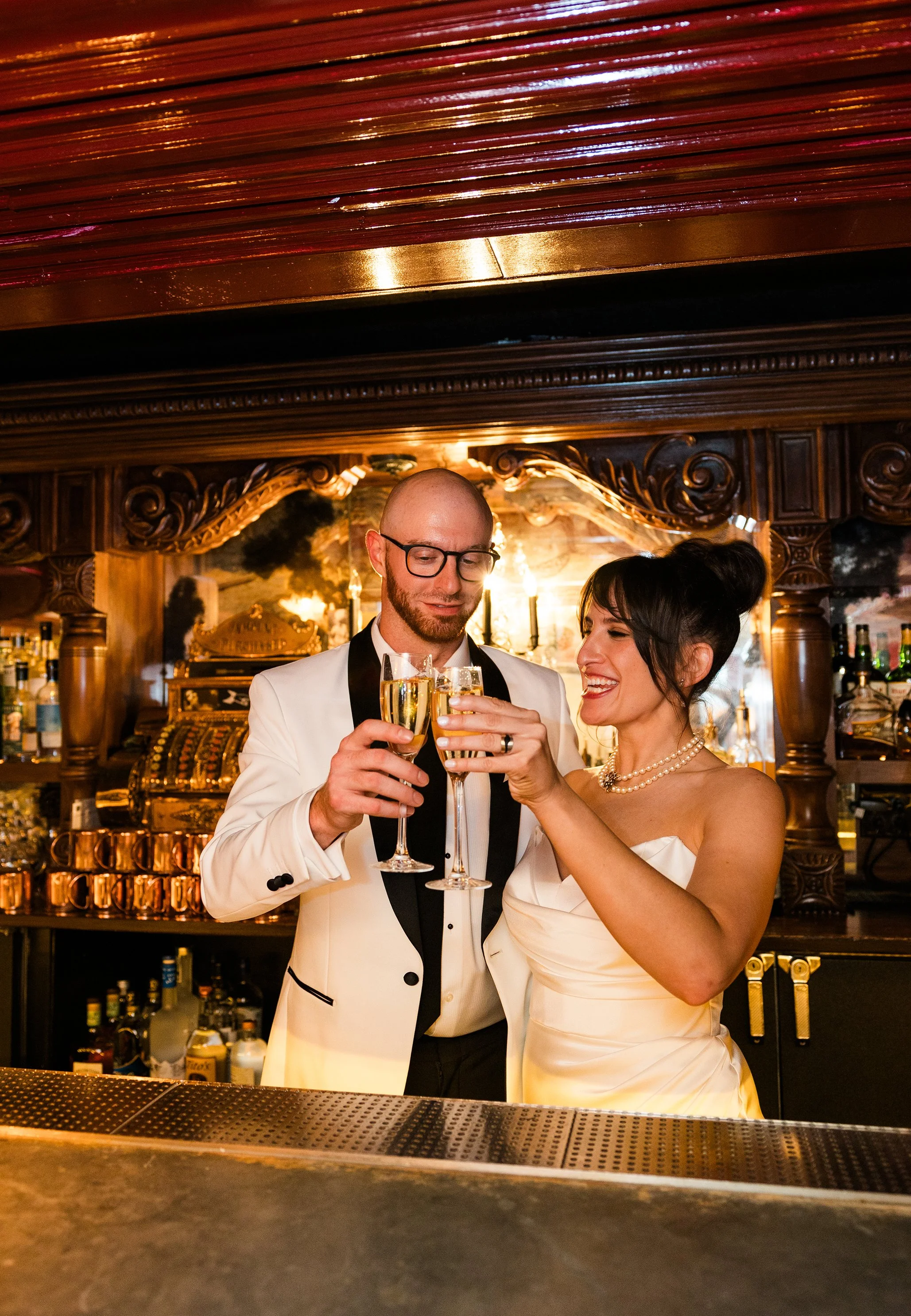  Documentary style wedding portrait of the bride and groom cheering at Gilt bar’s speakeasy the library. Classic Chicago wedding photography at a non traditional wedding space  