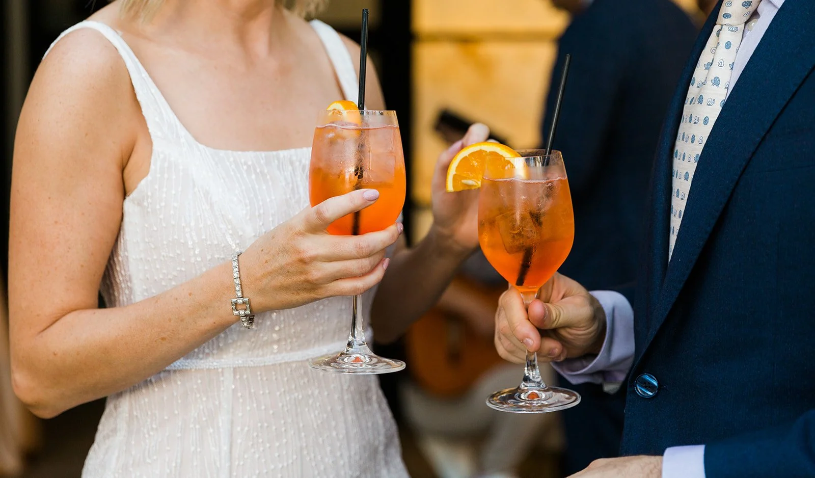  Documentary style candid photo of bride and groom cheersing aperol spritz’s at Gibsons Italia enjoying a nontraditional cocktail style wedding reception on the roof top patio over looking the Chicago Skyline.  