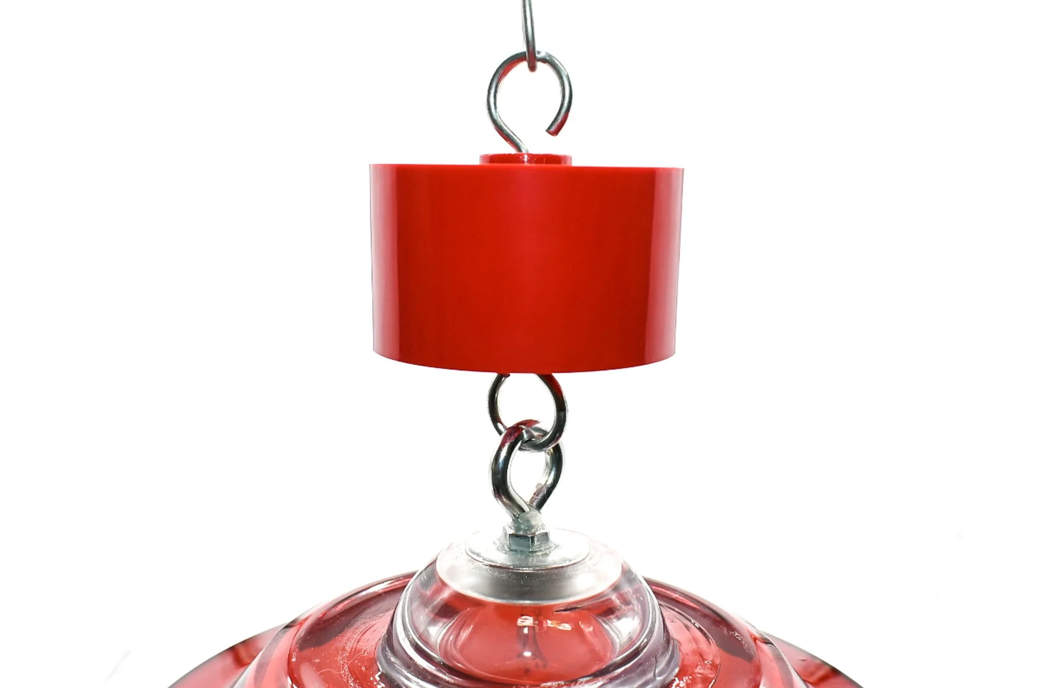 Red ant trap hanging between the support hook and the top of a bird feeder.