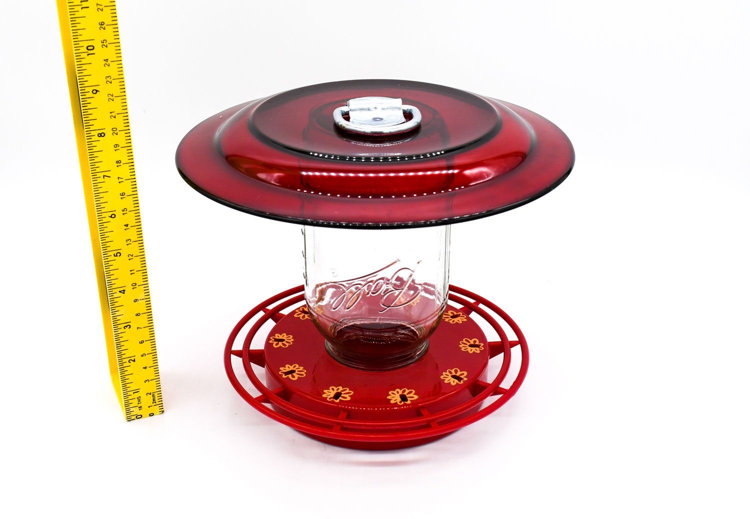 Handcrafted mason jar hummingbird feeder installed on garden pole