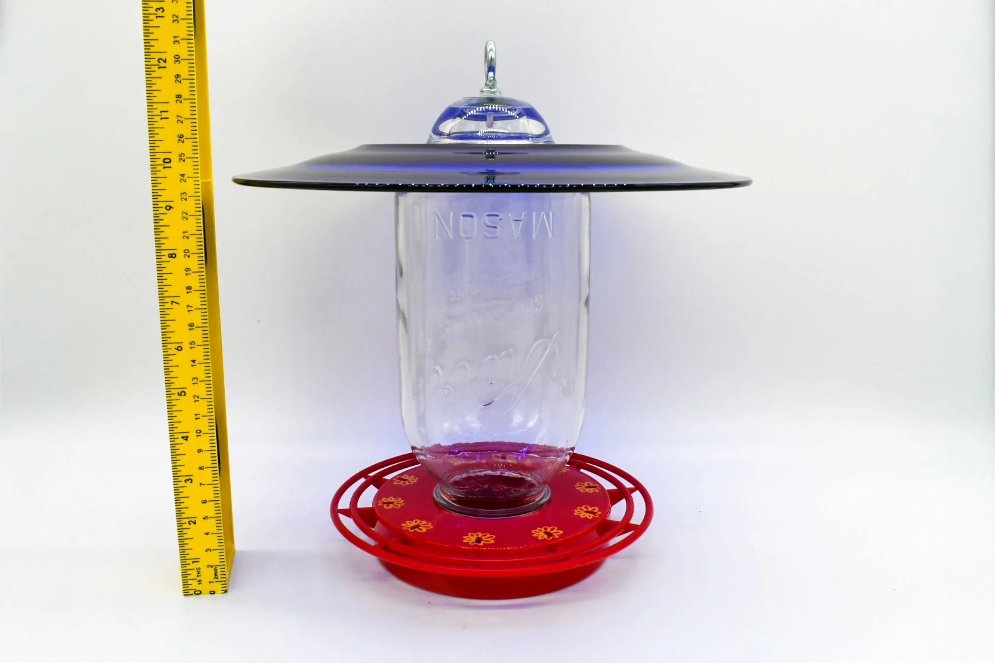 Front view of jumbo 64 oz Mason jar hummingbird feeder with cobalt glass plate and red Turbine base.