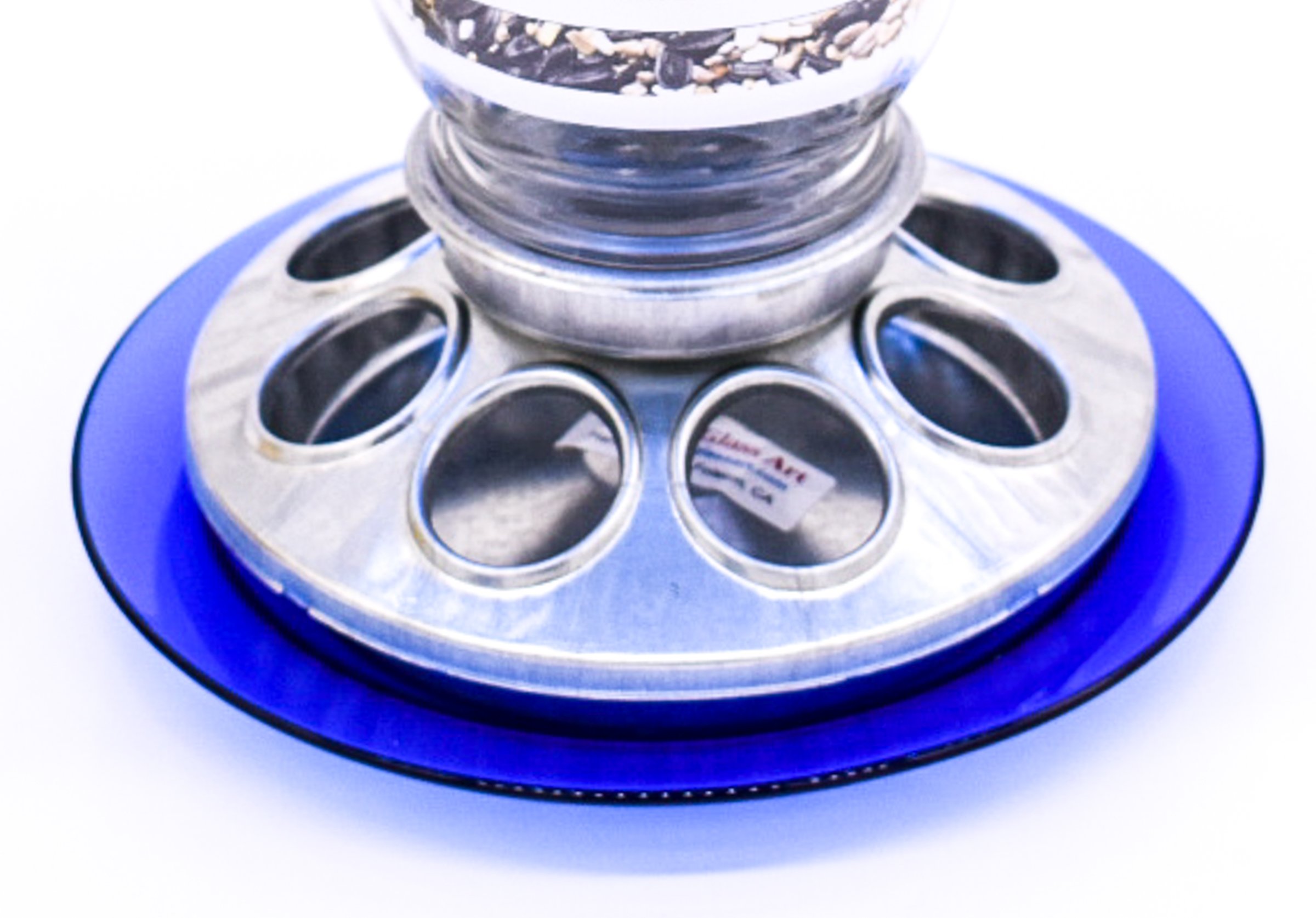 Close-up of galvanized metal bird feeder base showing circular mixed seed feeding ports