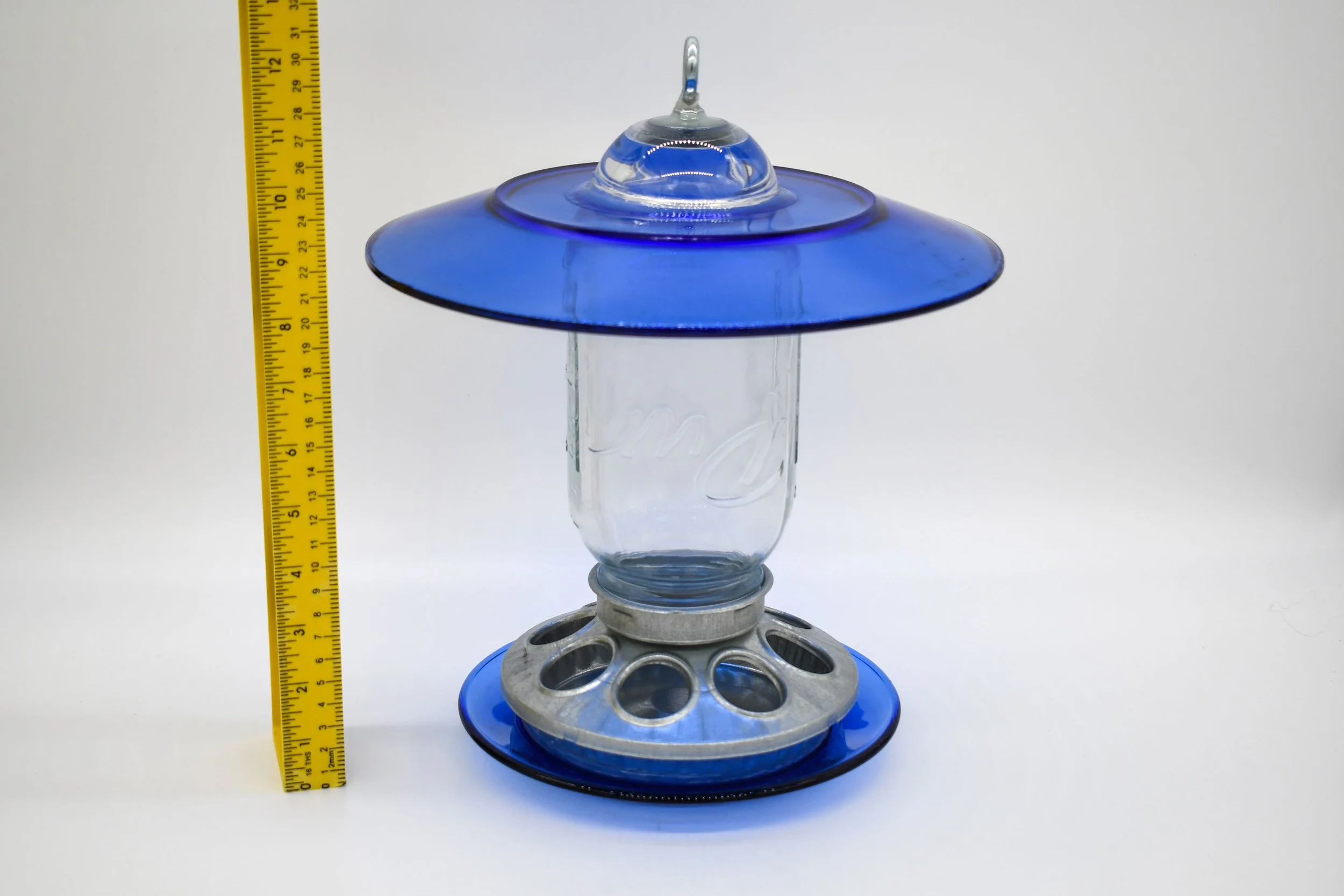 rRoyal blue glass Mason jar bird feeder shown beside ruler for overall height reference