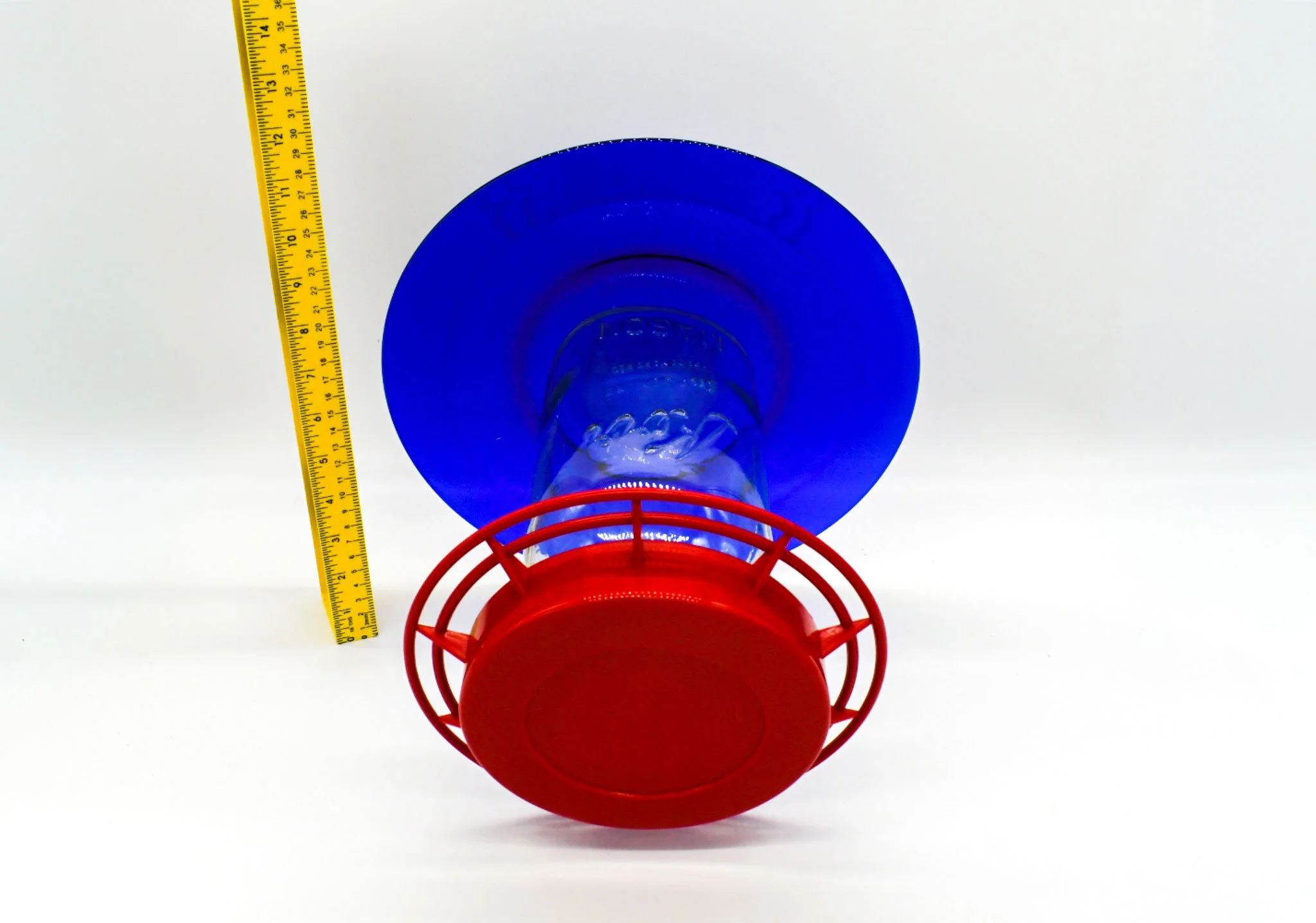 Bottom view of the cobalt glass feeder showing the red circular perch and feeding base.