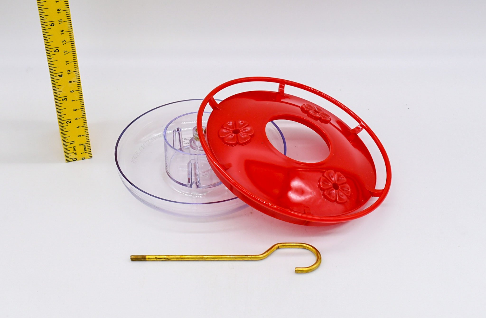 Disassembled Aspects HighView Mini hummingbird feeder showing removable cover, clear reservoir, and brass hanging rod for easy cleaning.