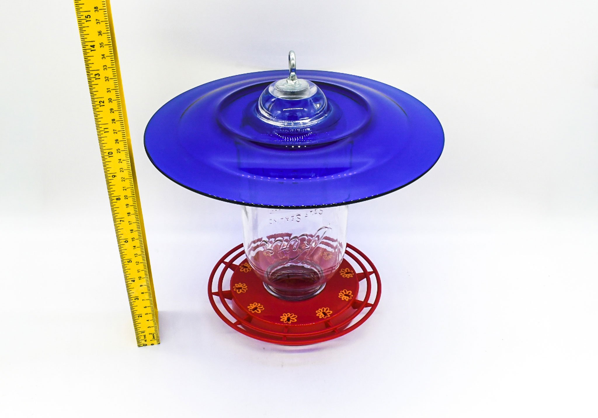 Underside view showing the cobalt glass plate, Mason jar reservoir, and circular red perches.
