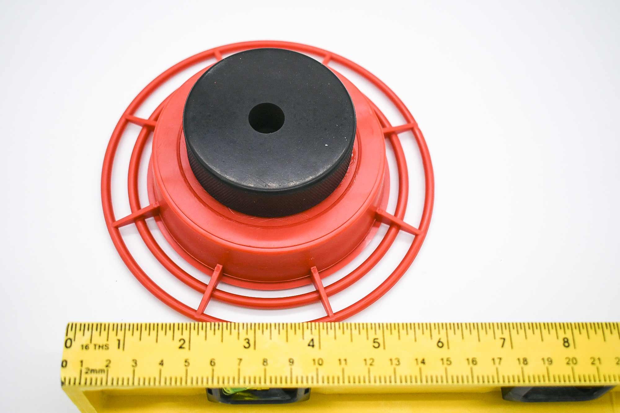 Red hummingbird feeder shown with ruler as a size and installation reference for the ERVA DAZ Ground Pole setup. Feeder not included.