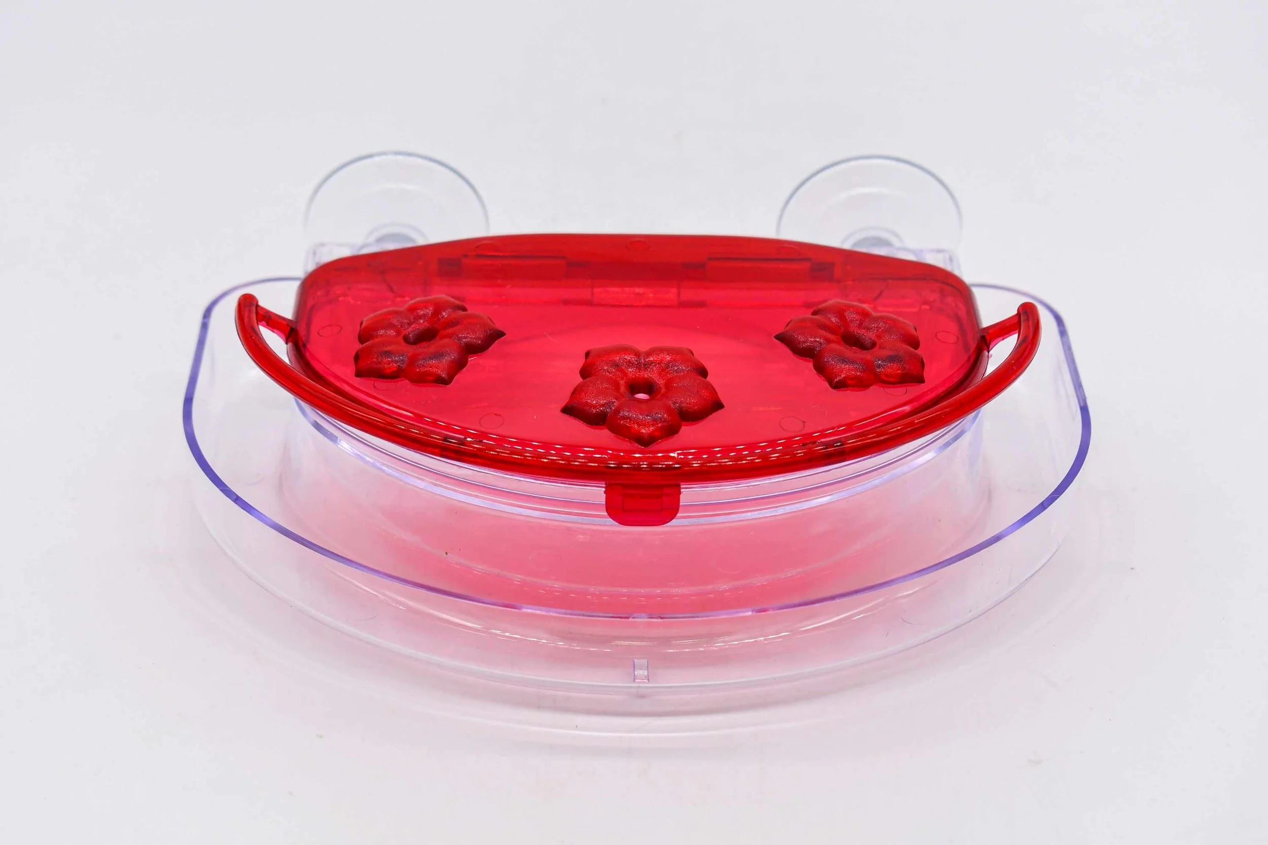Aspects 407 Jewel Box hummingbird feeder top view showing red cover, three feeding ports and clear nectar reservoir
