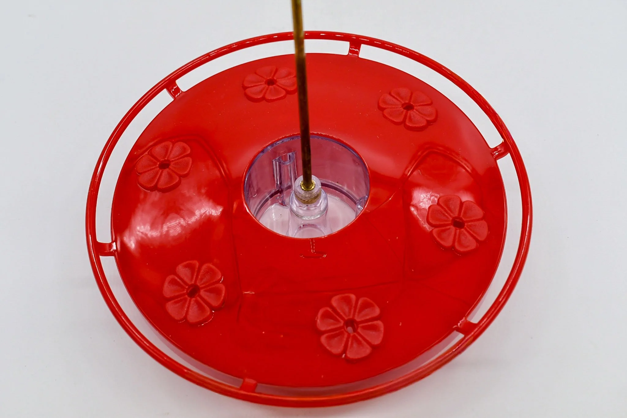 Top view of the red Aspects HighView Excel feeder showing its circular perch and six flower-shaped feeding ports.