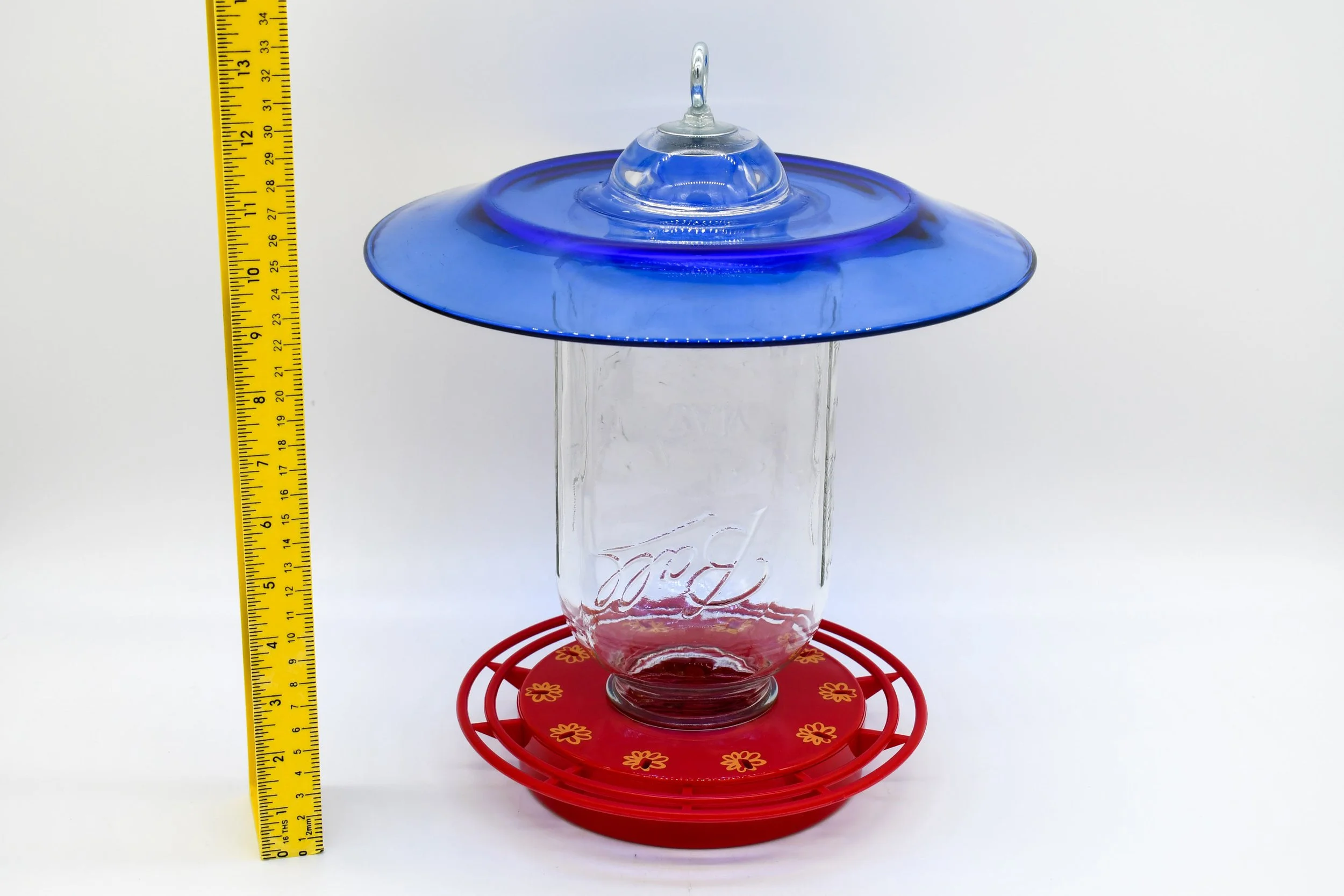 Angled view of the jumbo Mason jar feeder with cobalt blue glass and 10-station feeding base.