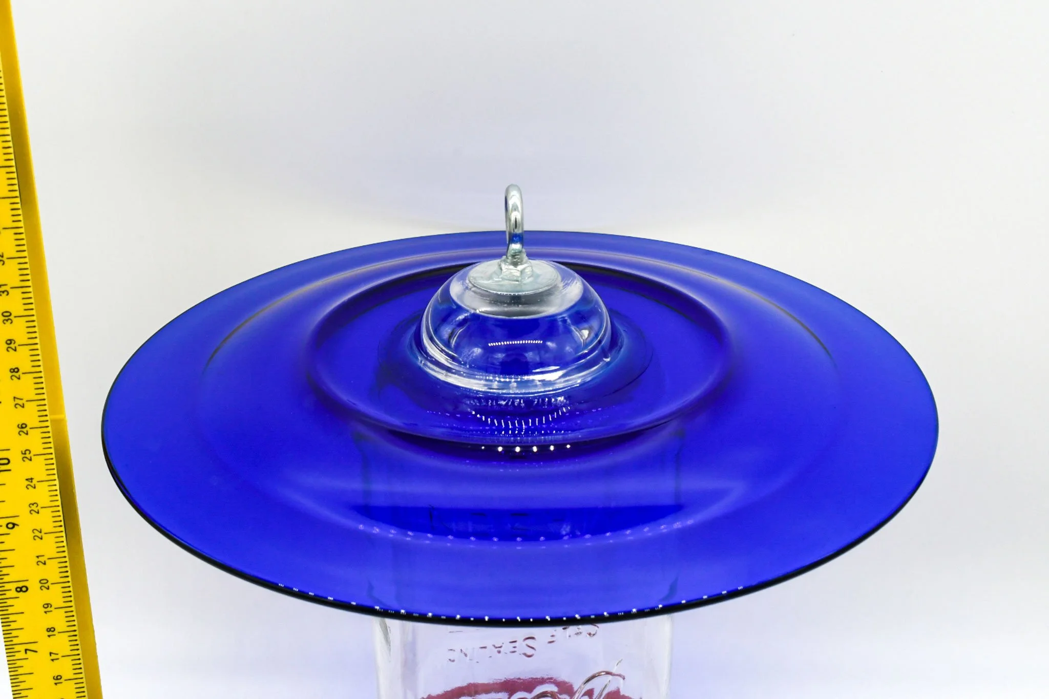 Close-up of the cobalt blue antique glass plate, glass votive, and galvanized hanging eye bolt.