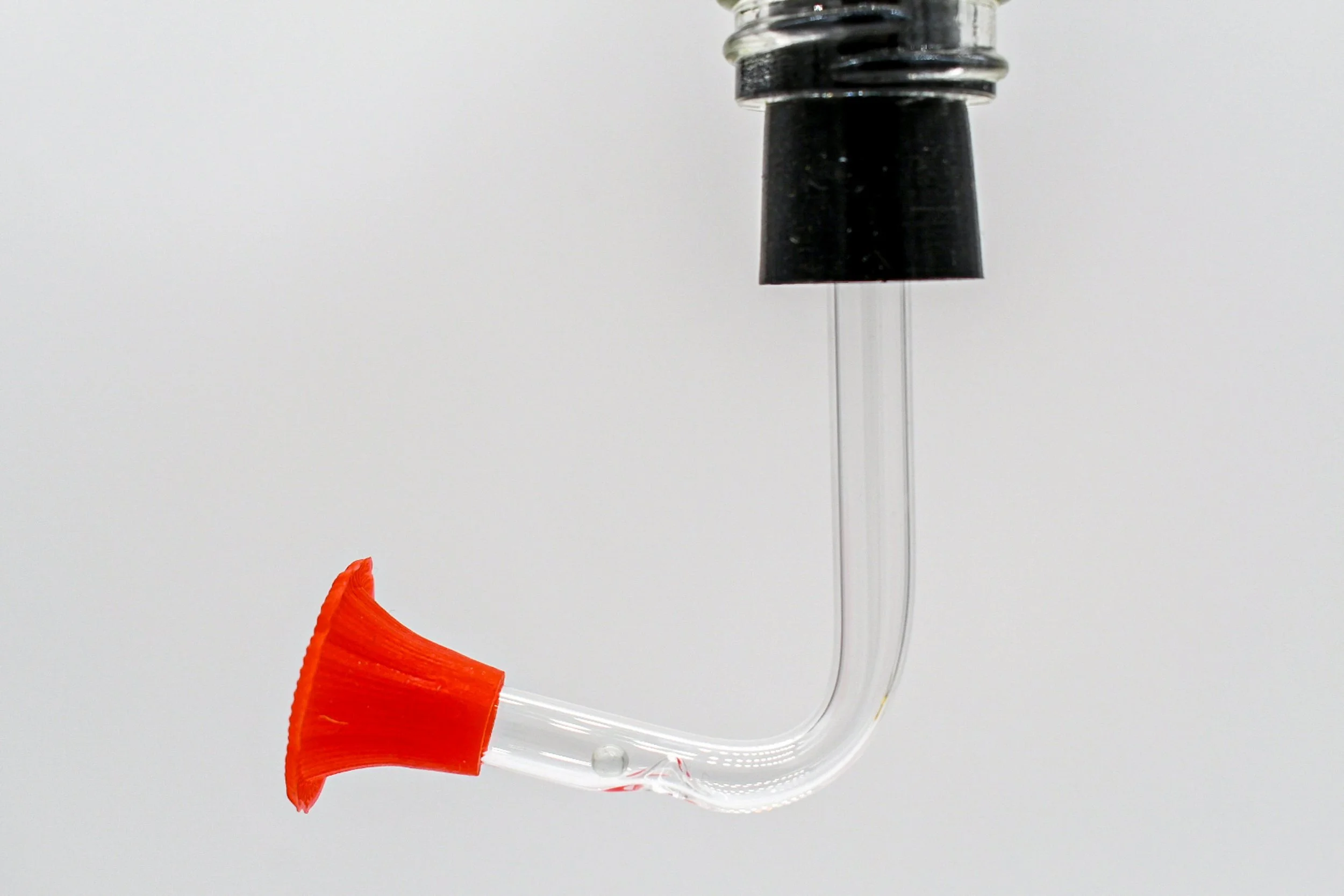 Side view of Songbird Essentials black rubber stopper with clear hummingbird feeding tube and red flower port
