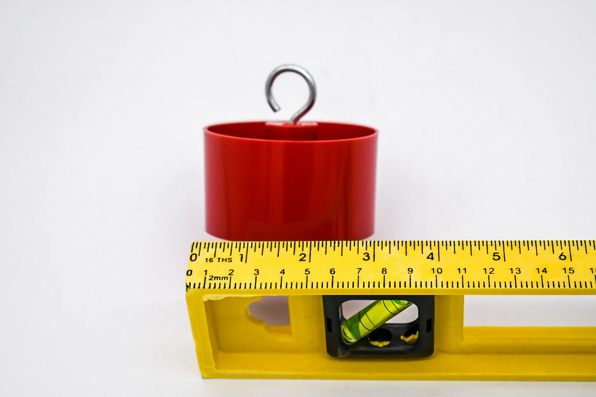 Measuring tape showing the approximate width of the red bird feeder ant trap.