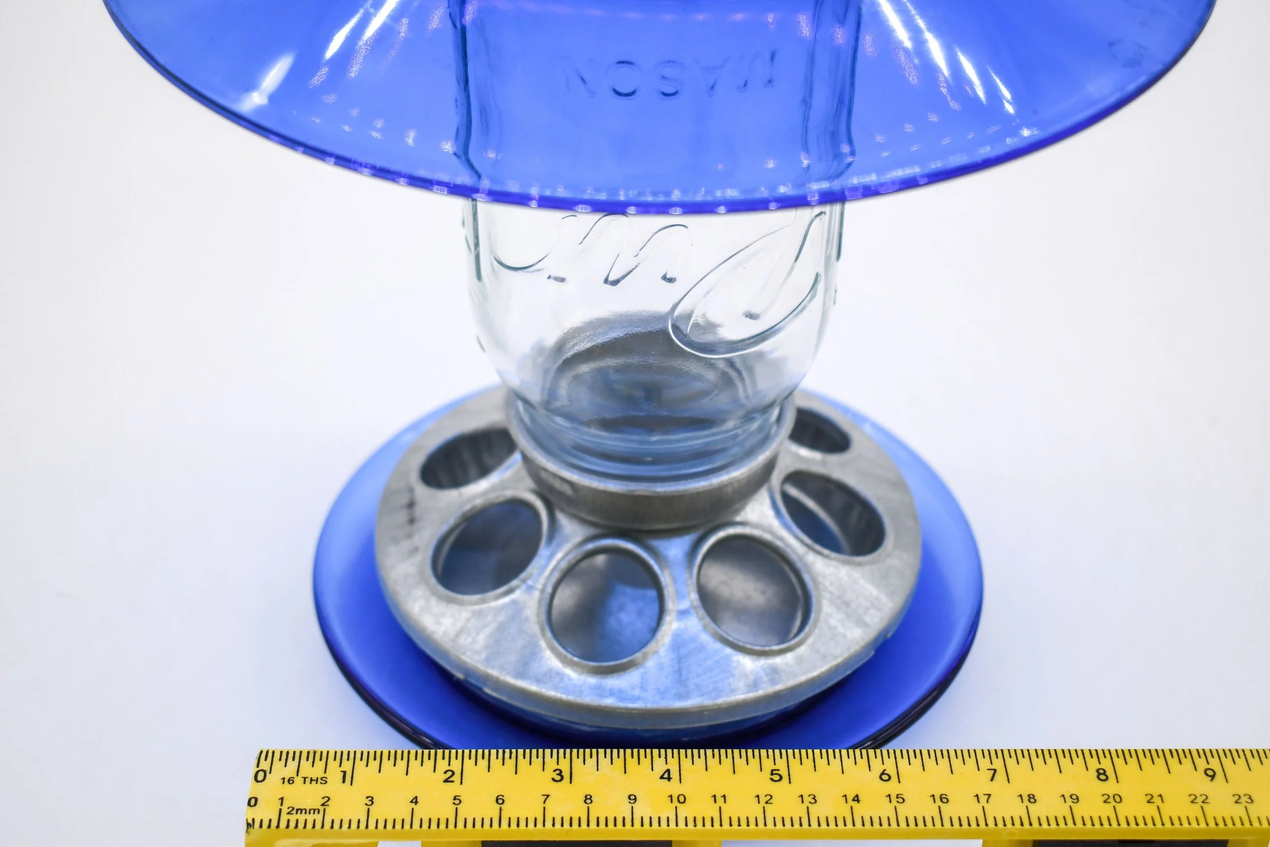Close-up of royal blue glass bird feeder with galvanized feeding ports and width measurement
