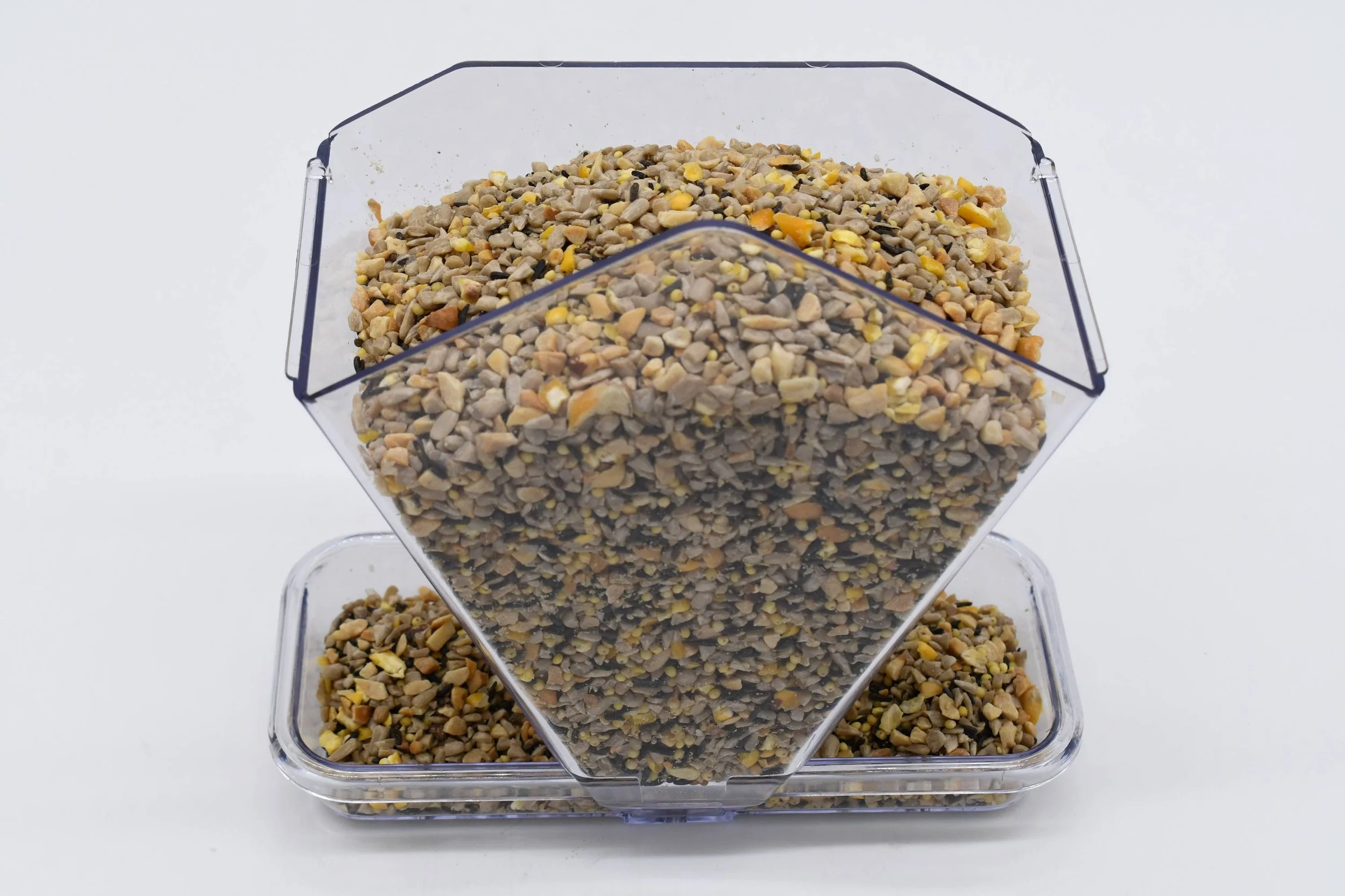 Close-up of the Aspects Window Cafe filled with mixed birdseed, highlighting its transparent polycarbonate reservoir and feeding tray.