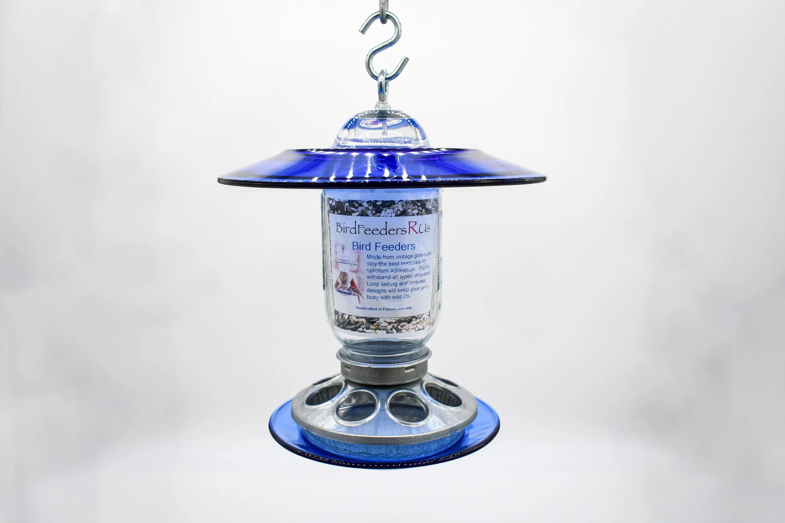 Royal blue glass hanging bird feeder with clear Mason jar and galvanized mixed seed feeding base