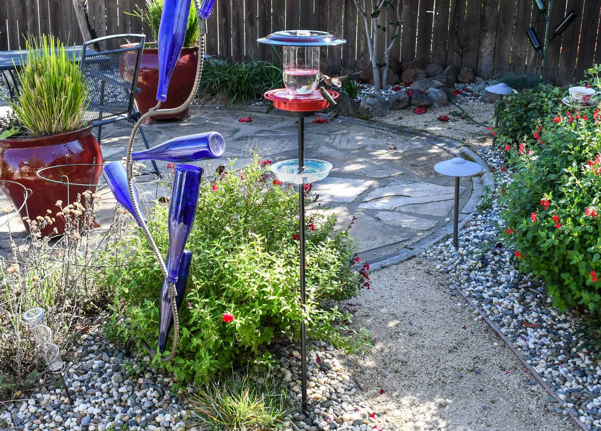 Hummingbirds feeding from pole mounted mason jar hummingbird feeder
