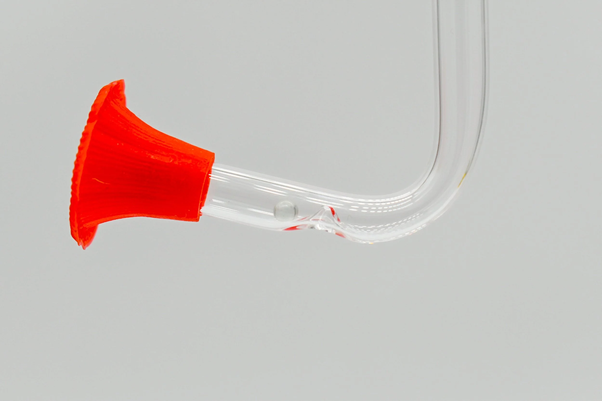Close-up of hummingbird feeder replacement tube with red flower shaped feeding port