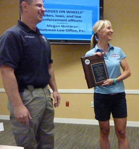 Megan shown above, accepting an award from Roy Denley and Colorado Police Unity Tour riders, during a Boulder Sheriff's Office briefing. (Photo credit: Andrew Tillin).