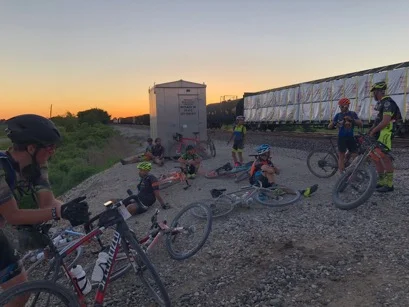 Disillusioned riders waiting for a parked train blocking the course, while the sun set! After 50 minutes of waiting a detour was authorized to get around it.