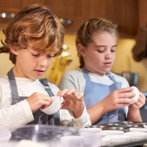 two children in Geneva cooking during a school holiday camp.