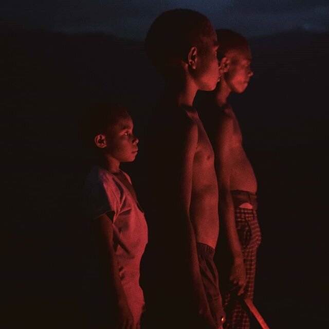 The picture shows three local children of the family tribe which hosted us while we stayed on Tanna Island. Just seconds before the picture was taken, a big eruption threw lava bombs hundreds of meters in the air and illuminated the scared young face