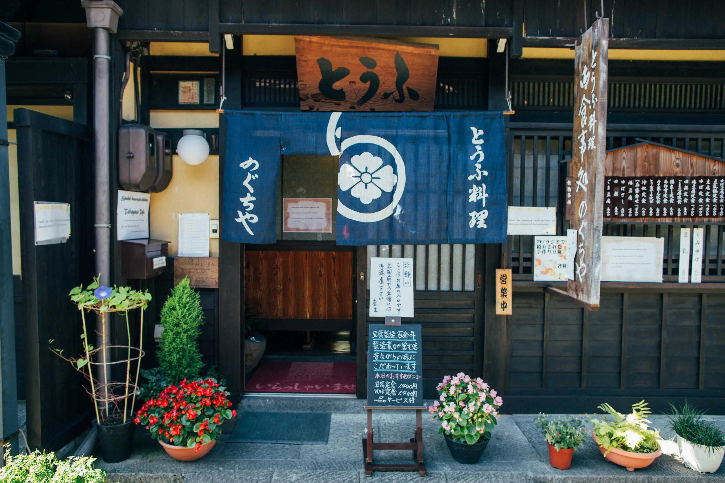 Shops in the old town of Takayama use traditional noren at their entrances. I think it's safe to assume that one segment flipped up means they are open for business.