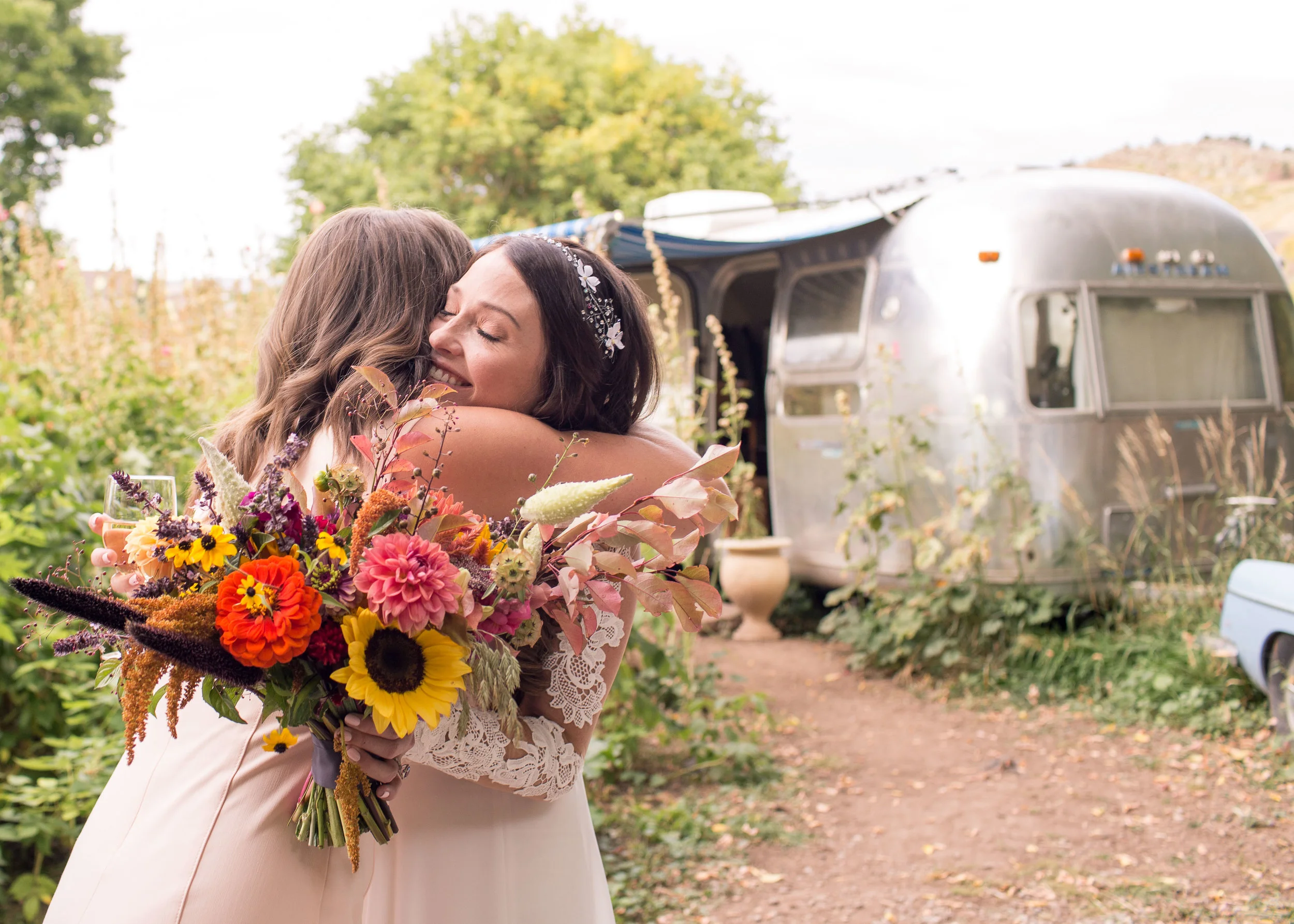 lyons farmette wedding, lyons colorado wedding, airstream, farmette, fall wedding, bride hugging friend