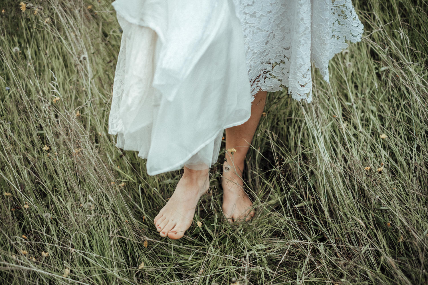 Braut bei Vintage-Sommerhochzeit Barfuß im Gras