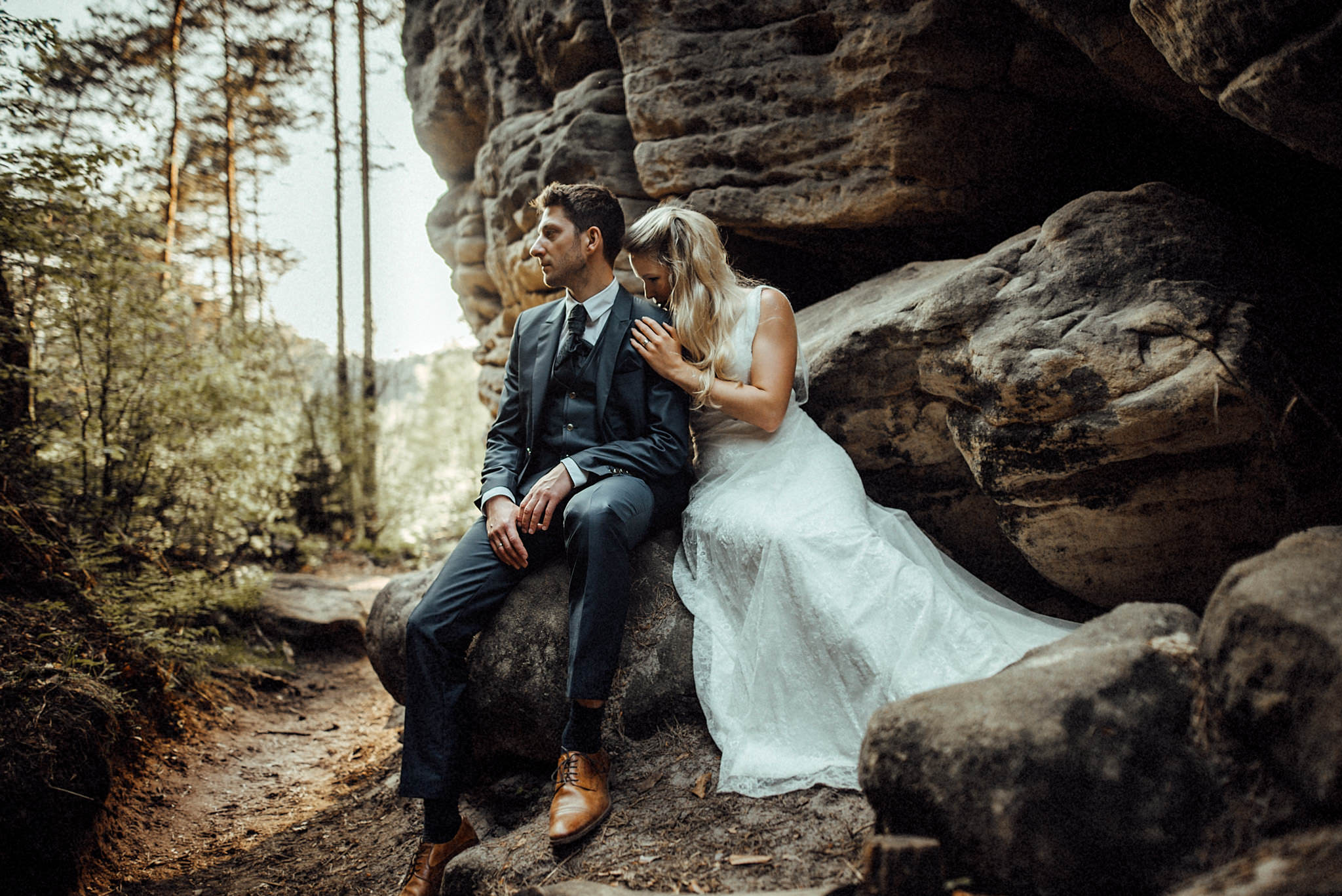 Das Foto zeigt das Hochzeitspaar beim After Wedding Elopement Shooting ind er Böhmischen Sächsischen Schweiz beim grandiosen Sonnenuntergang zwischen Felsen. 