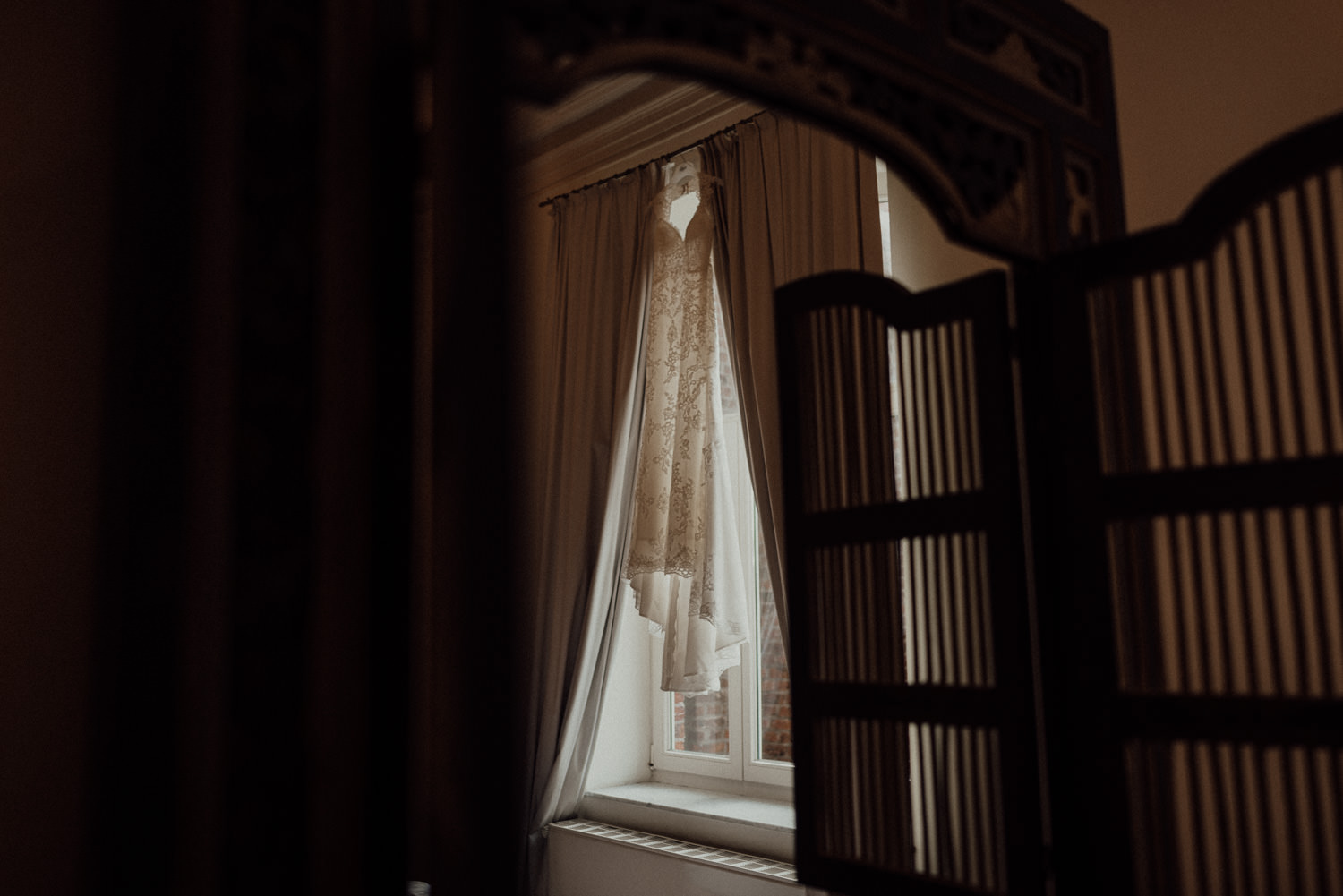 Brautkleid im Fenster hängend beim Getting-Ready