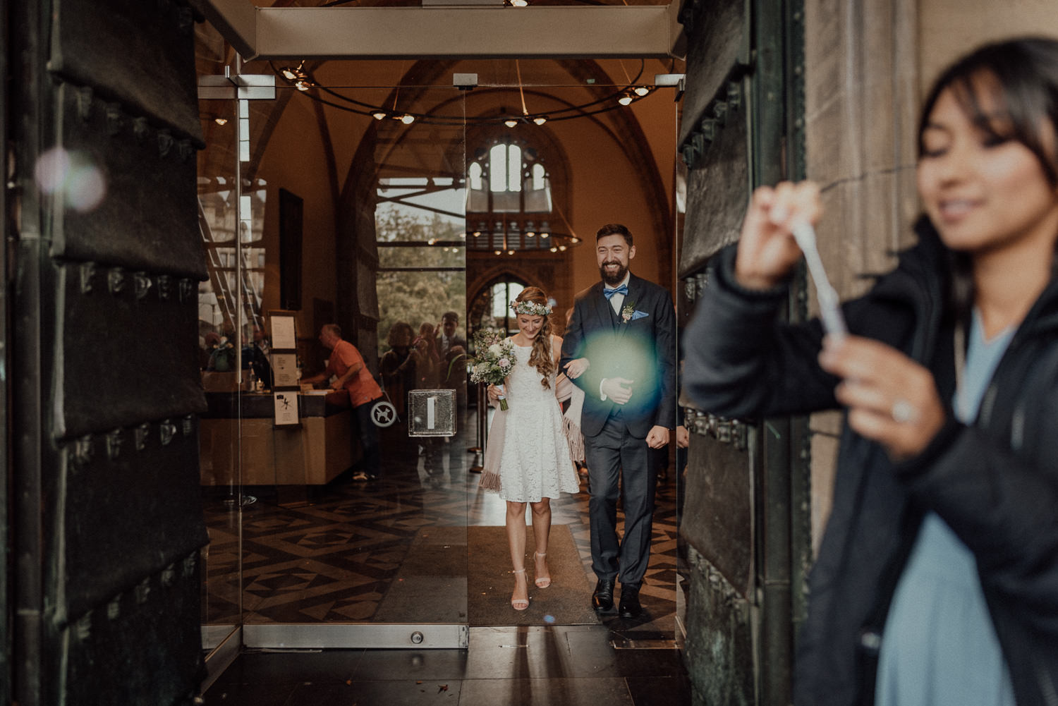 Überglückliches frisch vermähltes Brautpaar verlässt den weißen Saal in Aachen