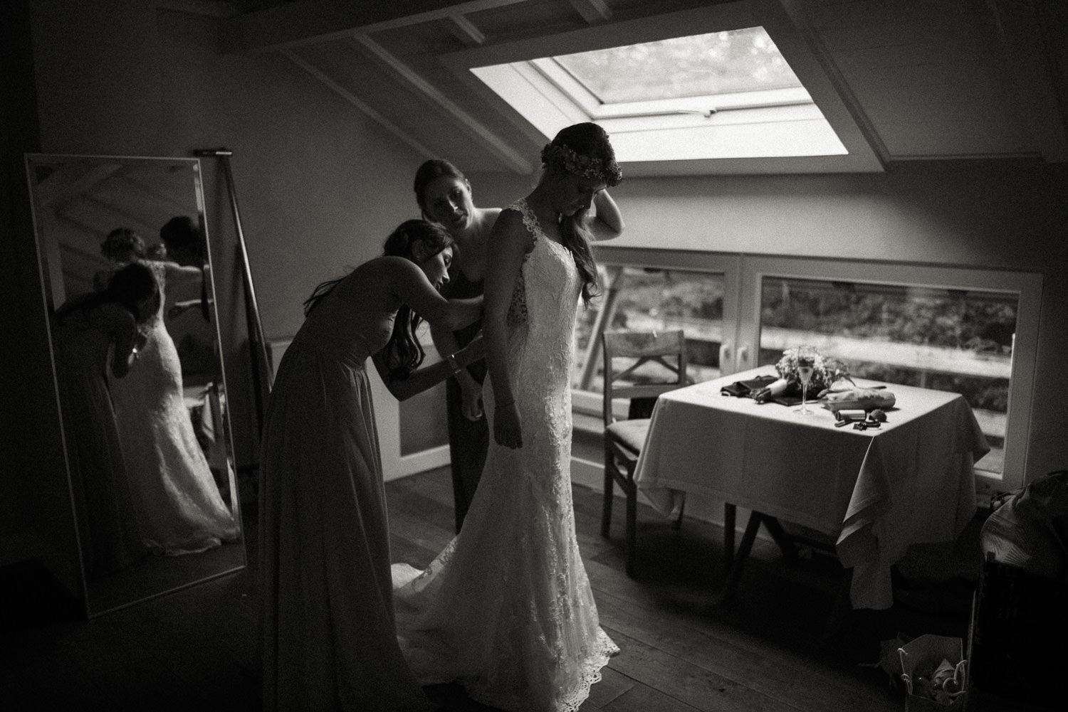 Die Brautjungfern helfen der wunderschönen Braut in ihr fabelhaftes Brautkleid für die bevorstehende freie Trauung im Wald nahe dem Lua Pauline, Aachen