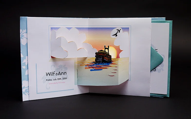 Handcut wedding invitation, made without glue. As the the card opens, the sun sets, and creates a reflection in the water as it drops behind the slits cut in the foreground. Photo by Natasha V