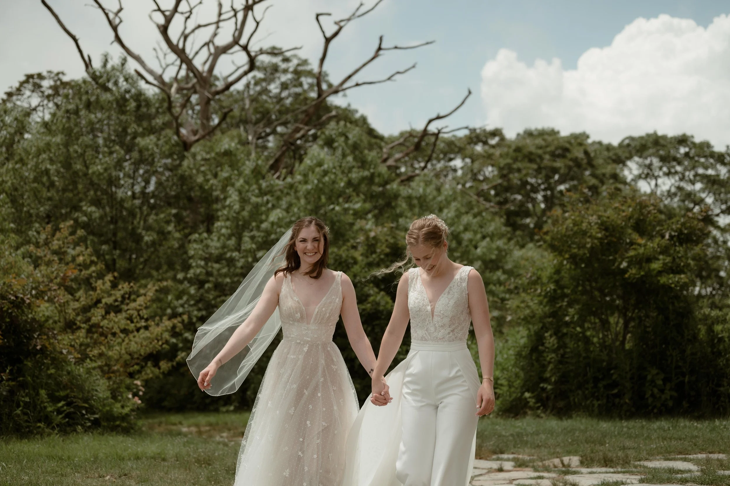 Cinematic North Carolina wedding photographer two brides walk along a stone path in Nantahala, North Carolina. Cinematic Memphis wedding photographer. Moody Memphis wedding photographer. Moody North Carolina wedding photographer.