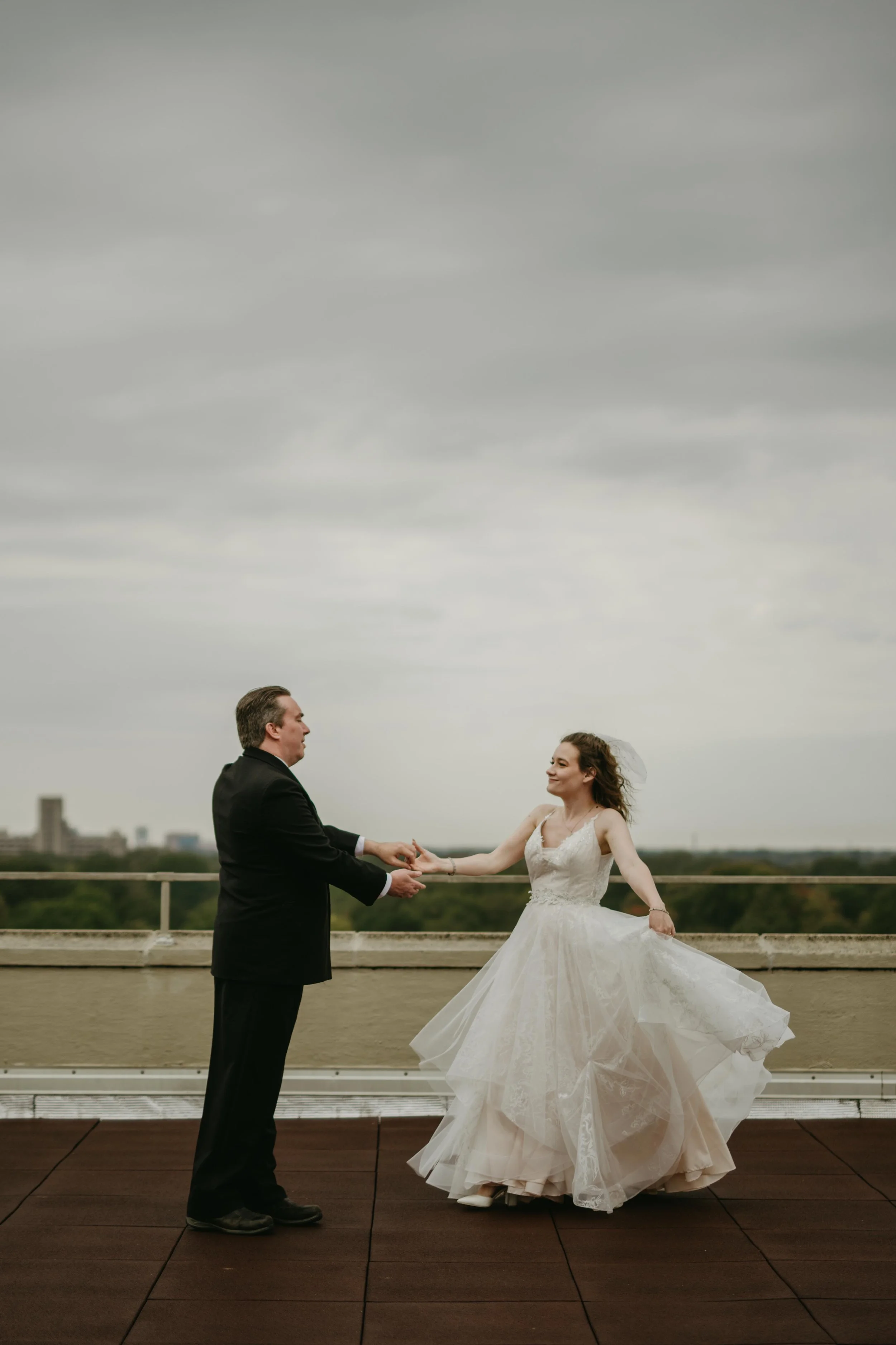 Moody Memphis wedding photographer a bride and groom pose on a rooftop with a view of the downtown Memphis skyline. Memphis Documentary wedding photographer. Cinematic Memphis wedding photographer.
