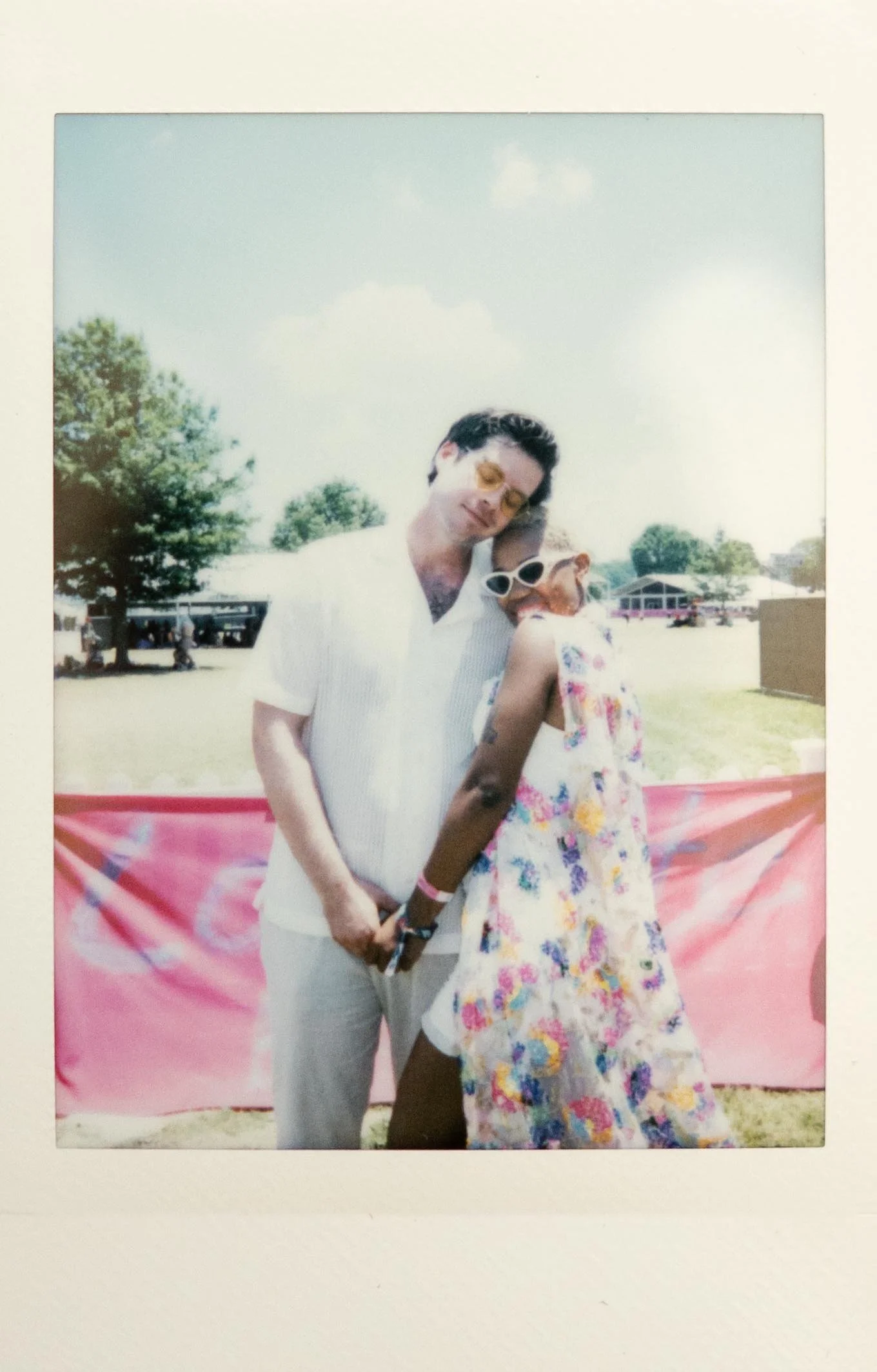 Instant film polaroid wedding photography a bride and groom pose at Bonnaroo. The bride wears a white mini dress and colorful floral cape. Moody Nashville wedding photographer. Nashville film wedding photographer.