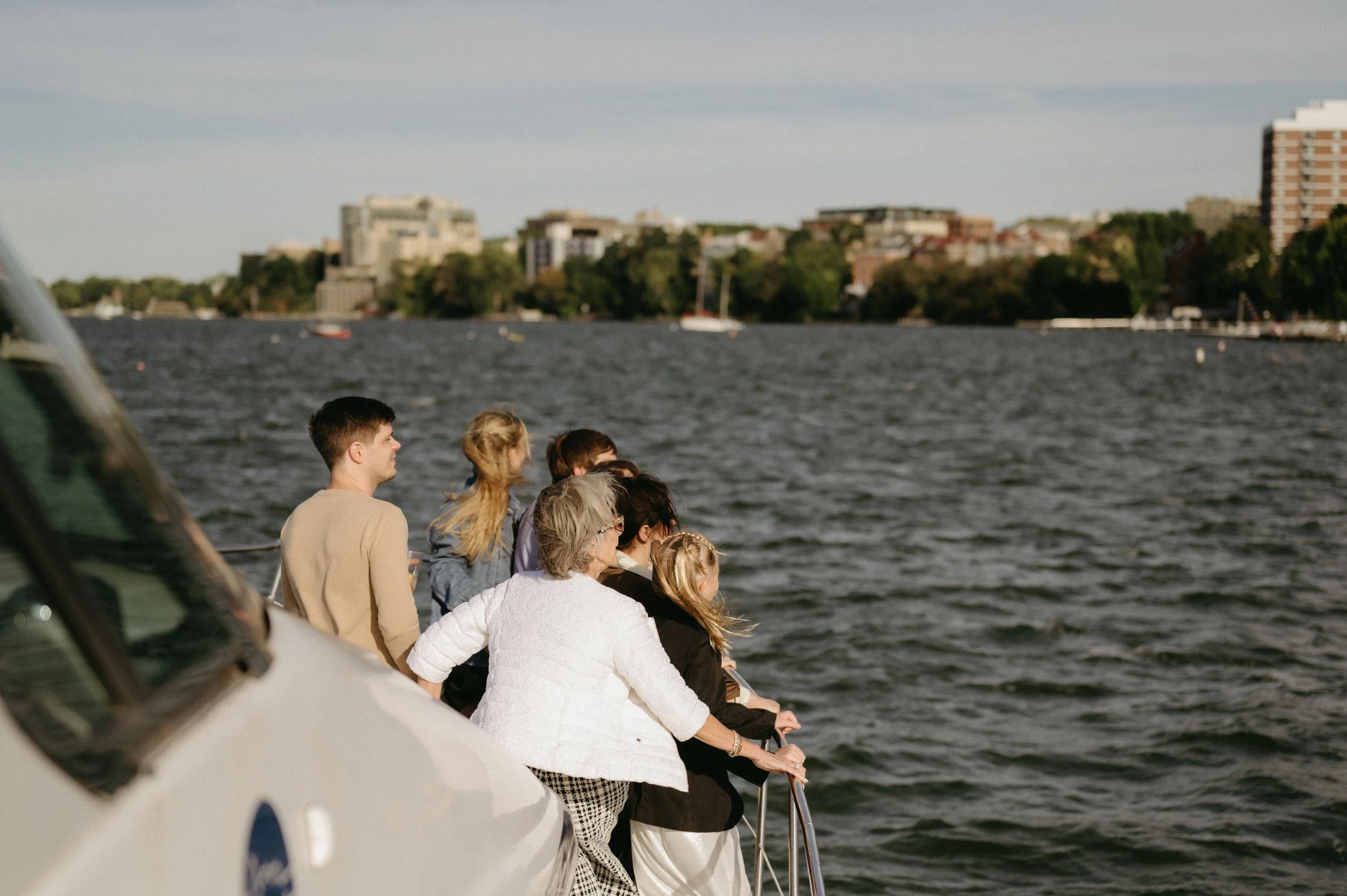 View of Lake Mendota and downtown Madison during a wedding weekend welcome dinner cruise in Madison, Wisconsin. Moody Madison wedding photographer. Documentary wedding photographer.