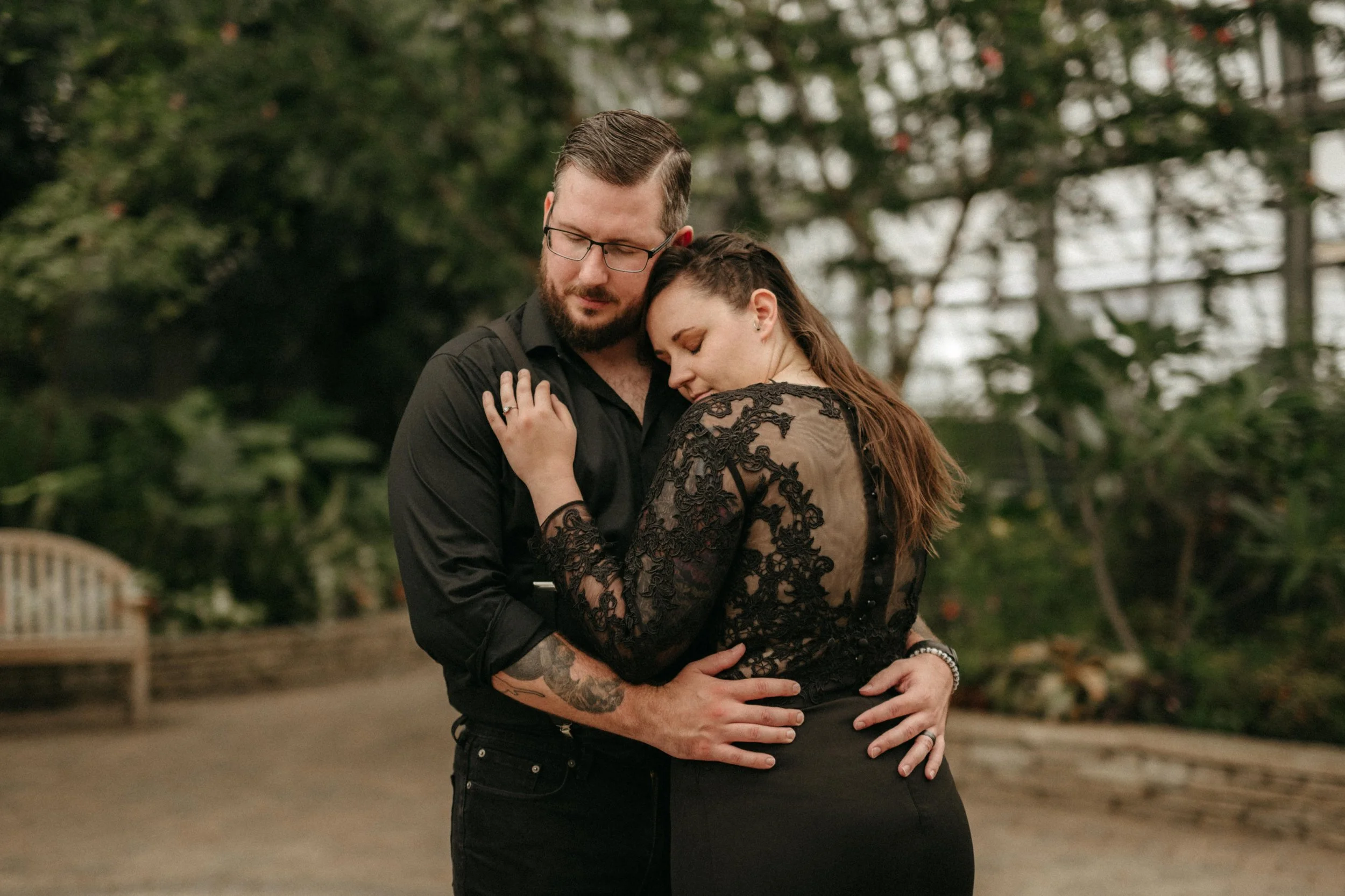 Moody, dramatic editorial bridal photoshoot in Chicago, Illinois. A couple wearing all black embrace. The bride wears a black lace wedding gown.