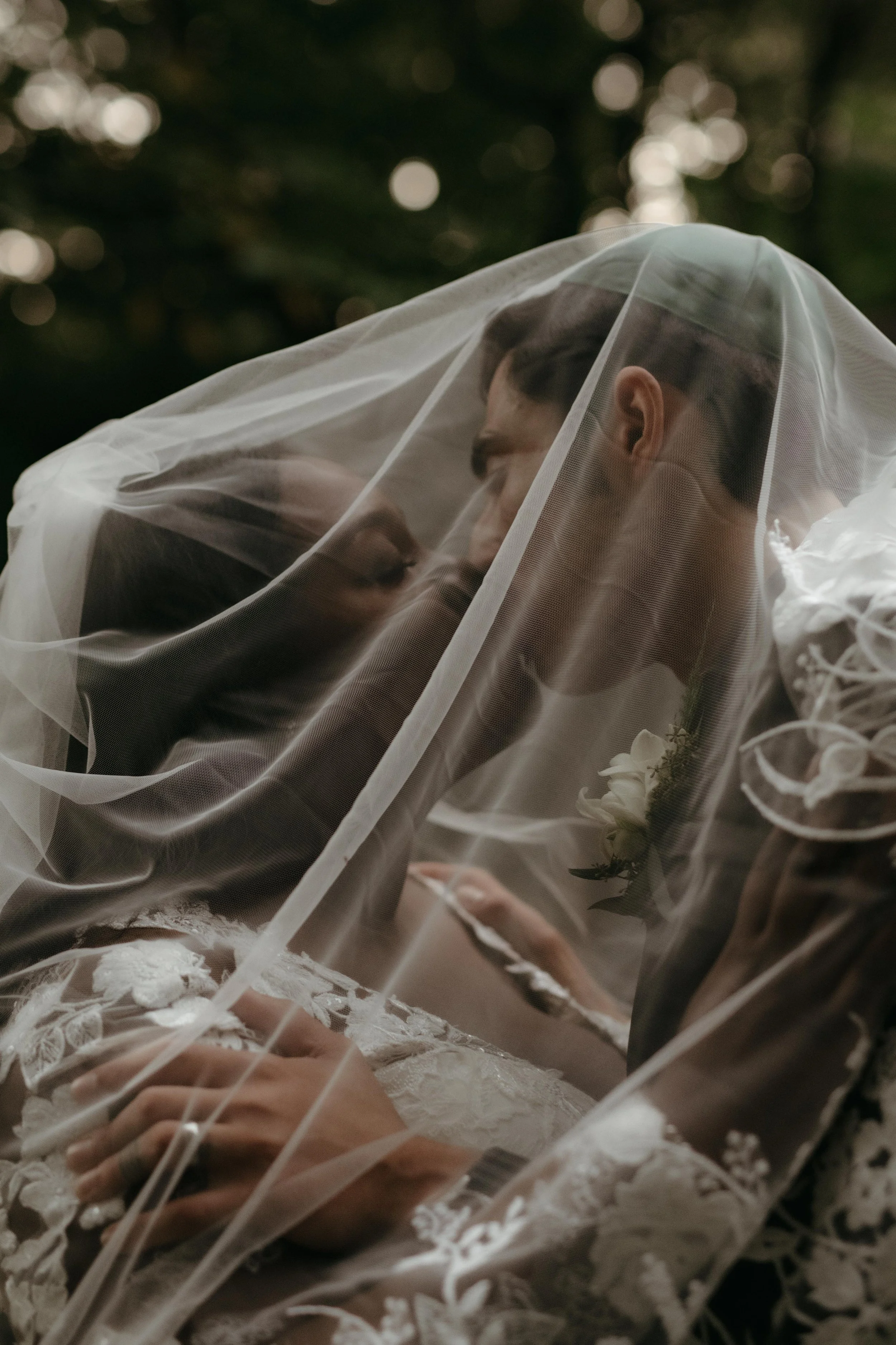 Moody wedding photo of a couple kissing under a veil at Lichterman Nature Center in Memphis, Tennessee.