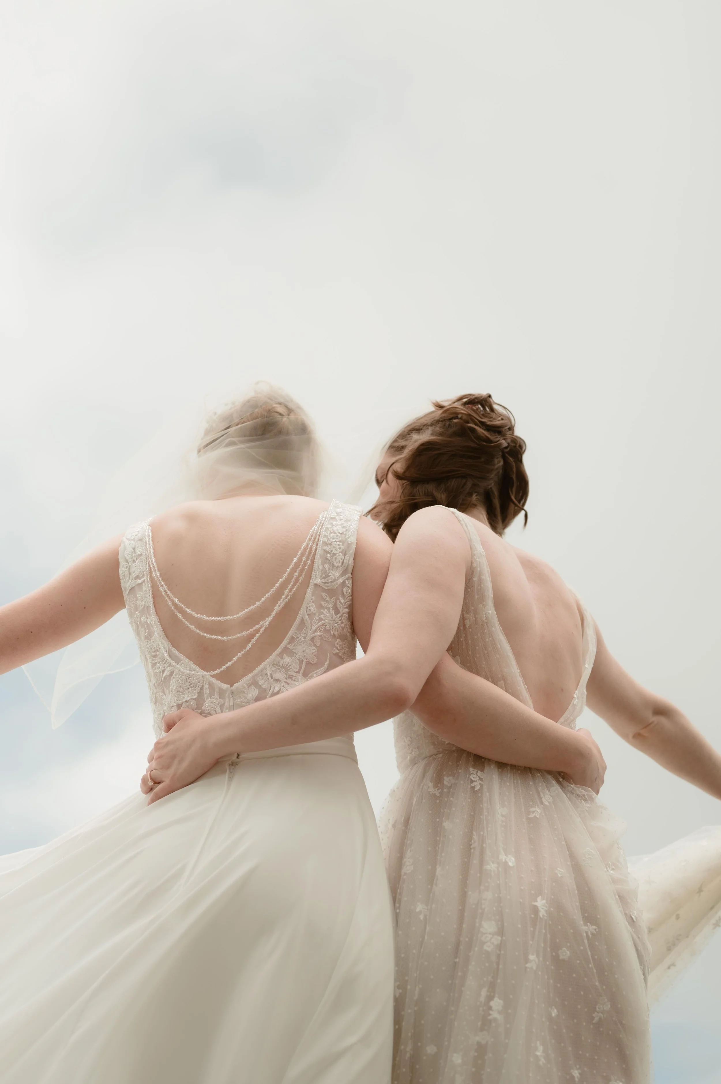 Cinematic North Carolina wedding photography two brides pose overlooking the Appalachian mountains in Nantahala, North Carolina. Cinematic Memphis wedding photographer. Moody Memphis wedding photographer. Moody North Carolina wedding photographer.