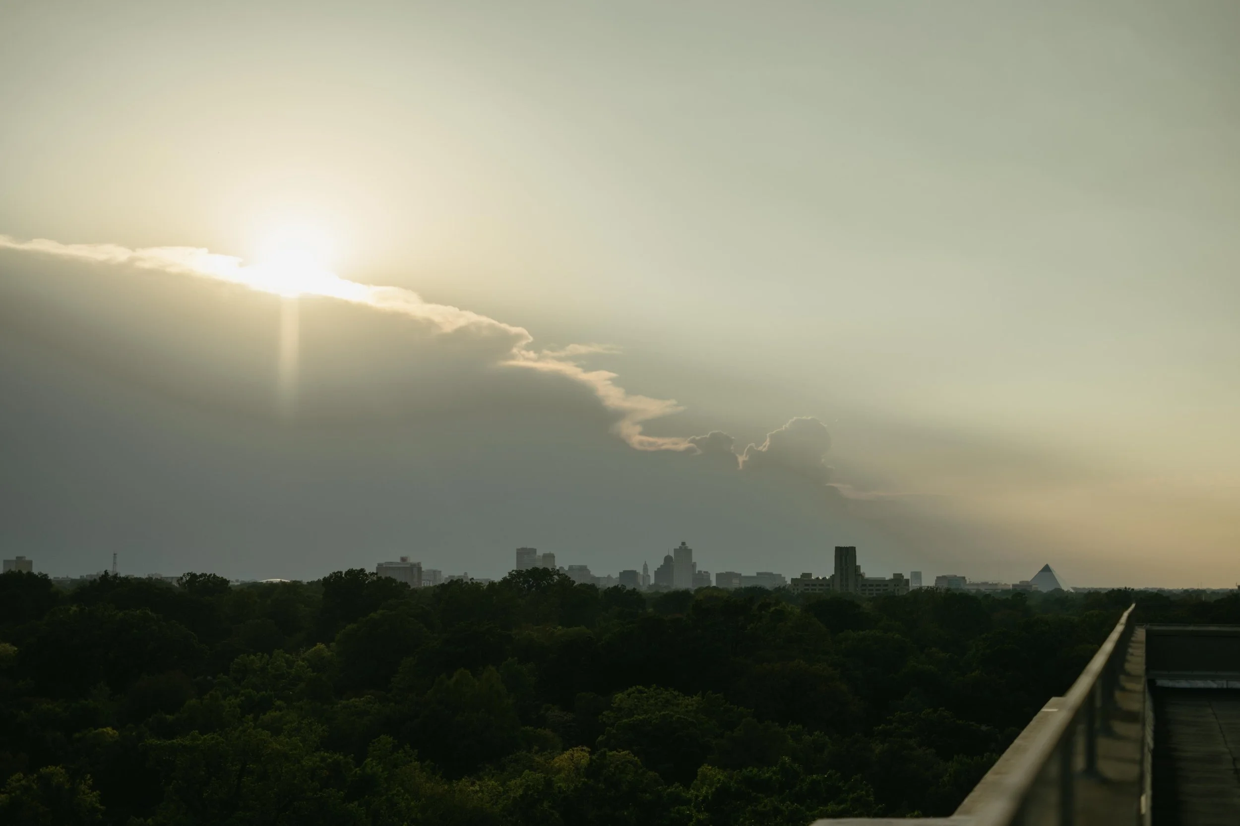 Moody Memphis wedding photographer a bride and groom pose on a rooftop with a view of the downtown Memphis skyline. Memphis Documentary wedding photographer. Cinematic Memphis wedding photographer.