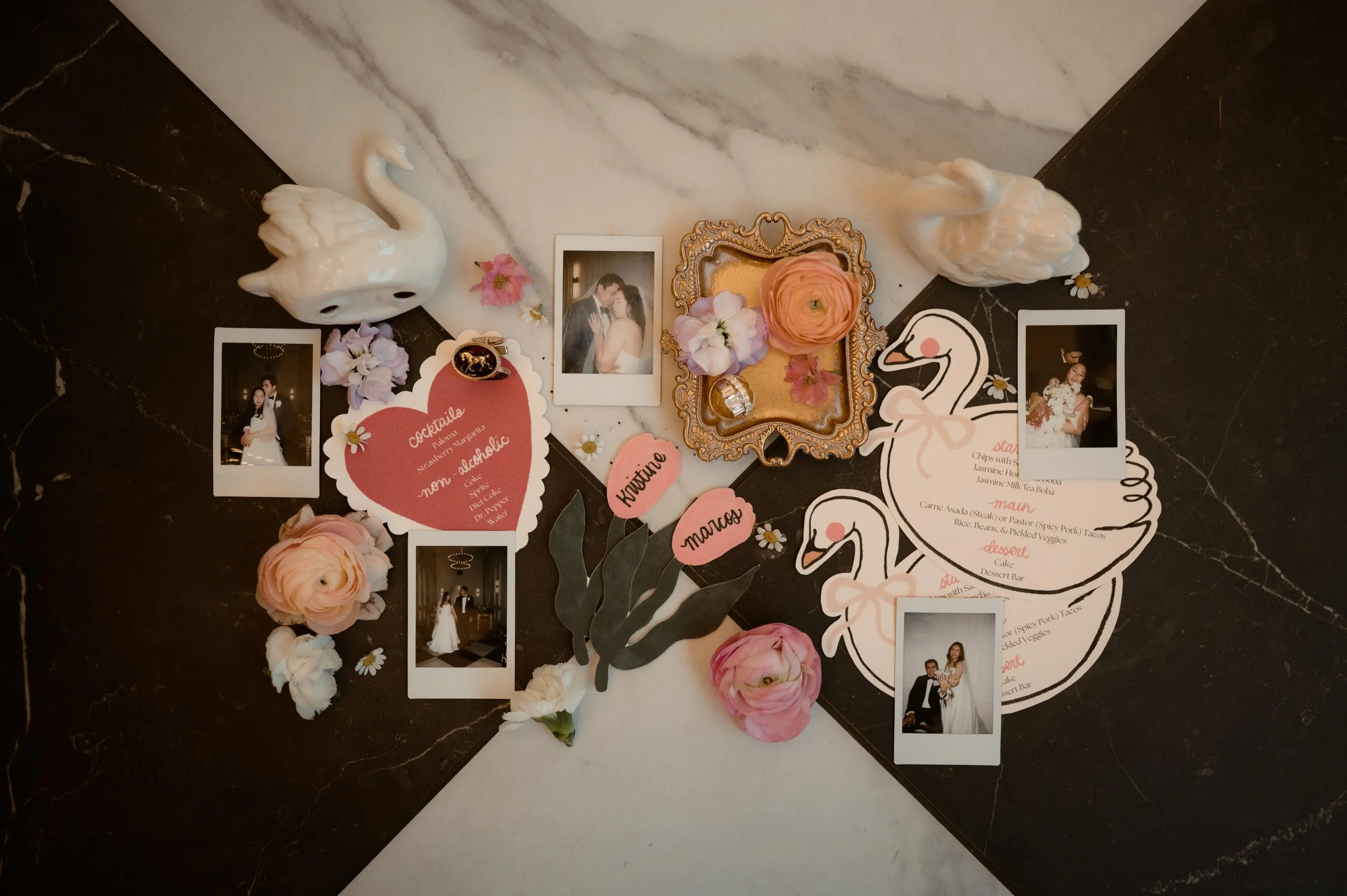 Moody wedding photography photo of wedding details, polaroid photos, table decorations, and pink flowers. Swan wedding decorations. Moody Huntsville Wedding Photographer. The Parisian in Huntsville, Alabama.