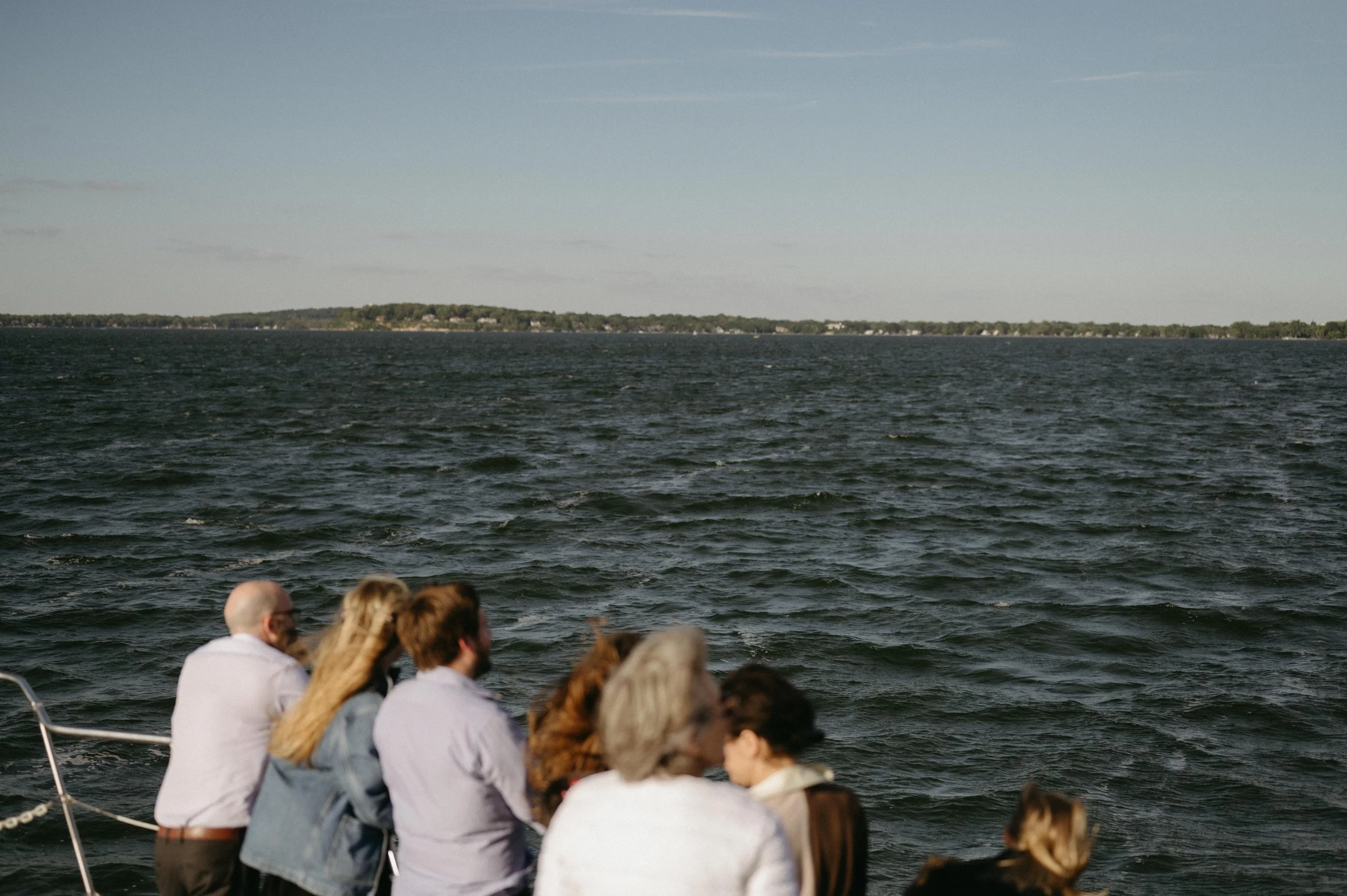 View of Lake Mendota during a wedding weekend welcome dinner cruise in Madison, Wisconsin. Moody Madison wedding photographer. Documentary wedding photographer.