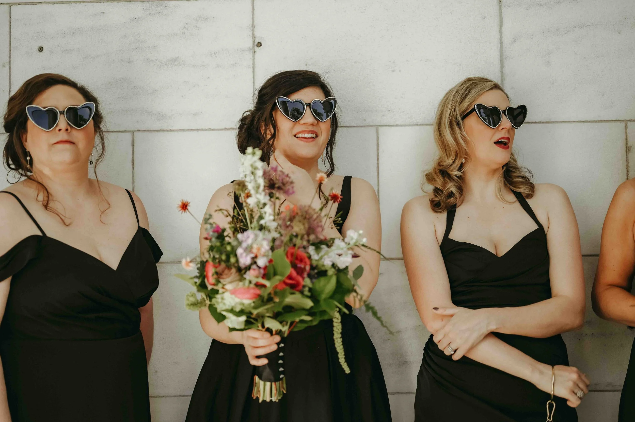Bridesmaids wearing all black and black sequined heart shaped sunglasses at the Brooks Museum in Memphis, Tennessee.