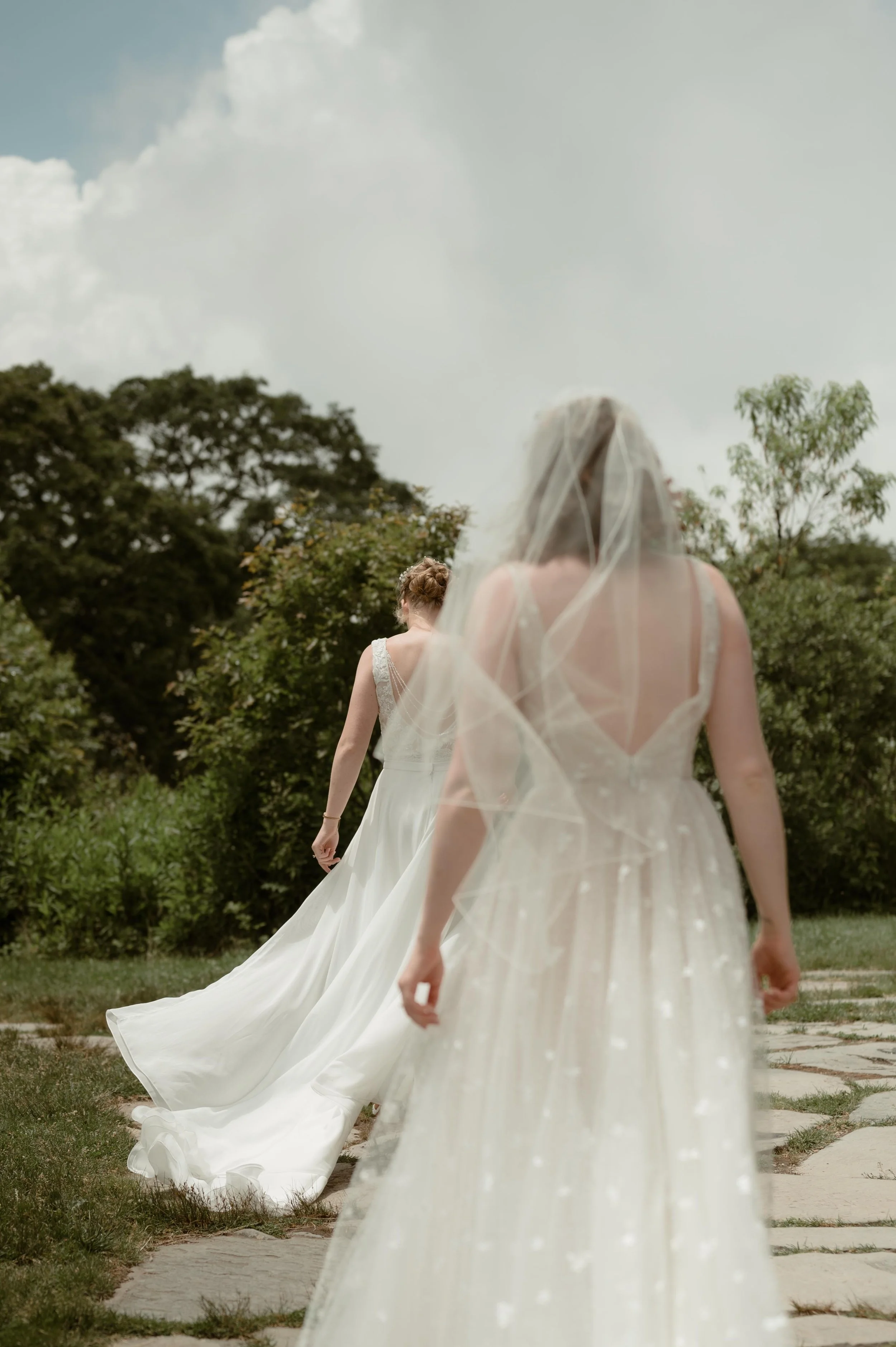 Cinematic North Carolina wedding photographer two brides walk along a stone path in Nantahala, North Carolina. Cinematic Memphis wedding photographer. Moody Memphis wedding photographer. Moody North Carolina wedding photographer.