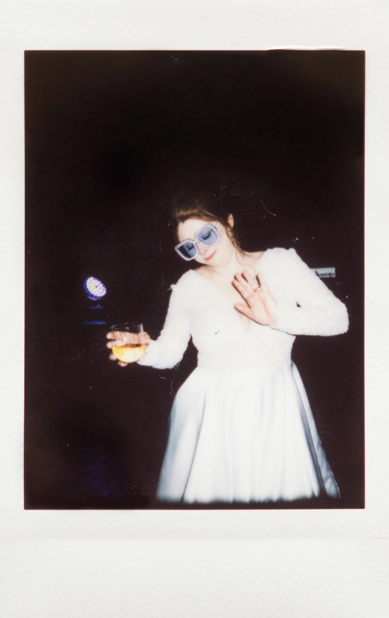 Instant film polaroid wedding photography a bride dancing while holding a drink and wearing blue sunglasses at The Kent in Memphis, Tennessee. Moody Memphis wedding photographer. Memphis film wedding photographer.