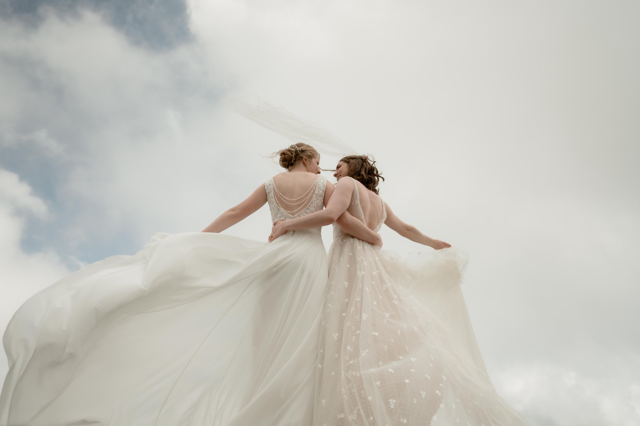 Cinematic North Carolina wedding photography two brides pose overlooking the Appalachian mountains in Nantahala, North Carolina. Cinematic Memphis wedding photographer. Moody Memphis wedding photographer. Moody North Carolina wedding photographer.
